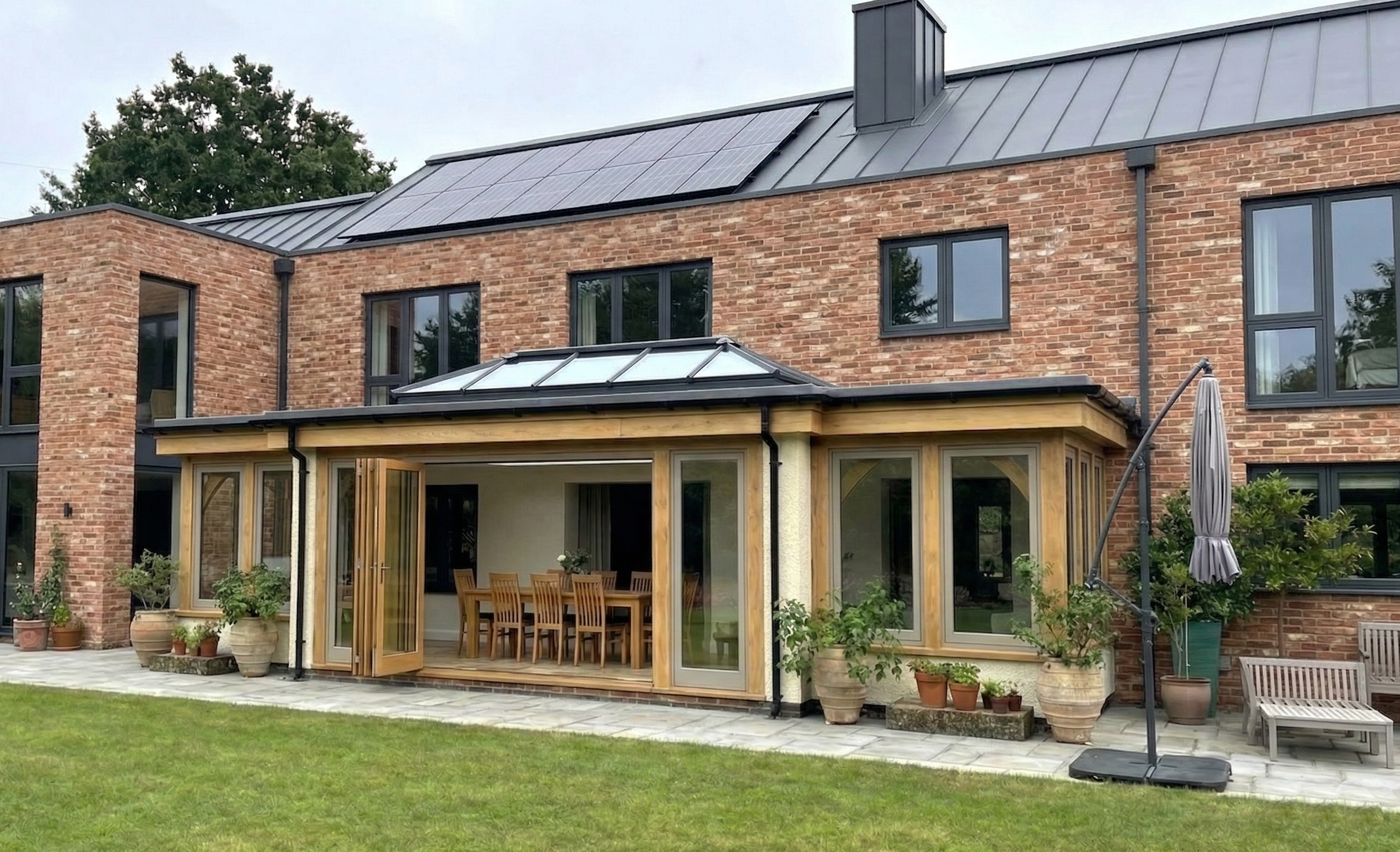 Bespoke oak-framed orangery extension featuring a traditional flat roof and large glazed windows.