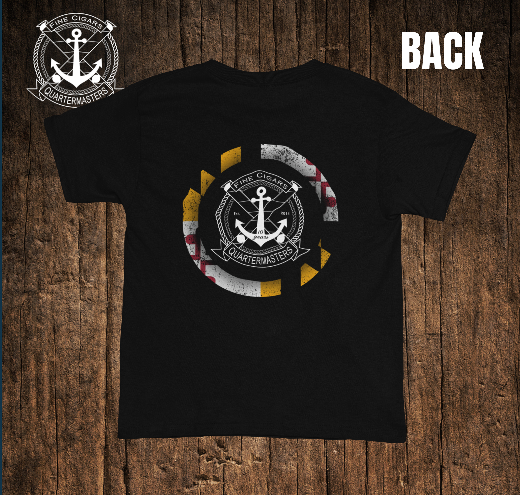 Back of a black T-shirt with a nautical-themed logo surrounded by a distressed circular stripe in yellow, white, red, and black colors. The logo features an anchor, rope, and a banner that reads 'Fine Cigars' and 'Quartermasters'.