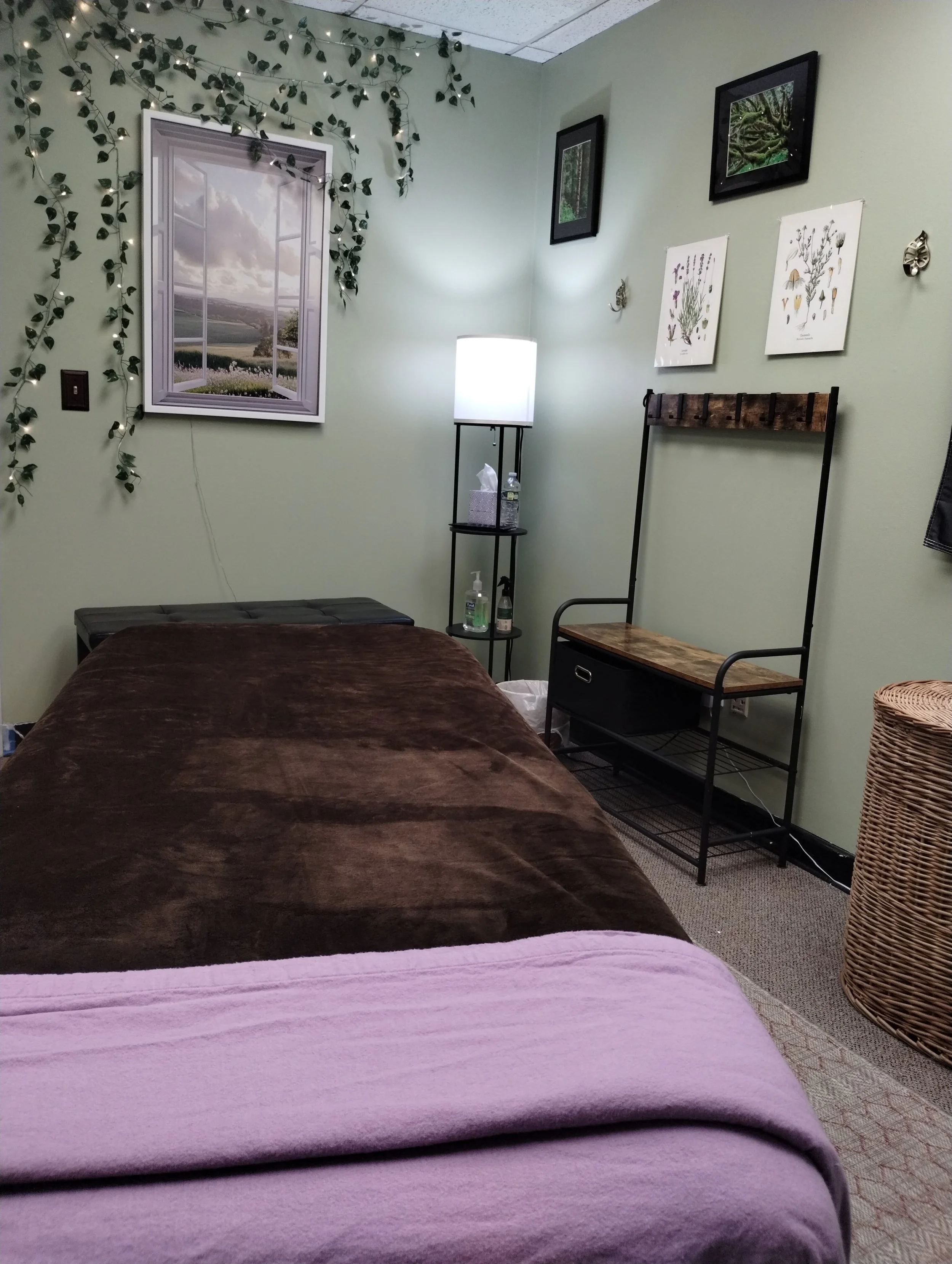 The trauma-informed therapy room at Resting Squirrel in Merrimack, NH, featuring a professional massage table with lilac sheets.