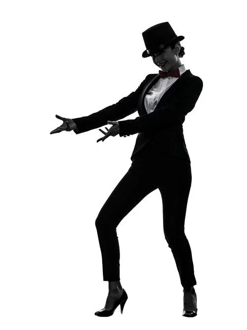 Silhouette of a woman in a tuxedo, top hat, and bow tie, dancing with one hand extended and the other near her waist.