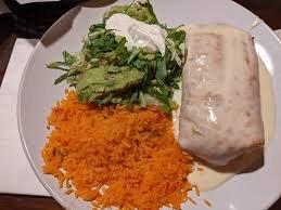 Plate with a piece of salmon, a serving of mashed sweet potatoes, and a side salad with greens and a dollop of white sauce