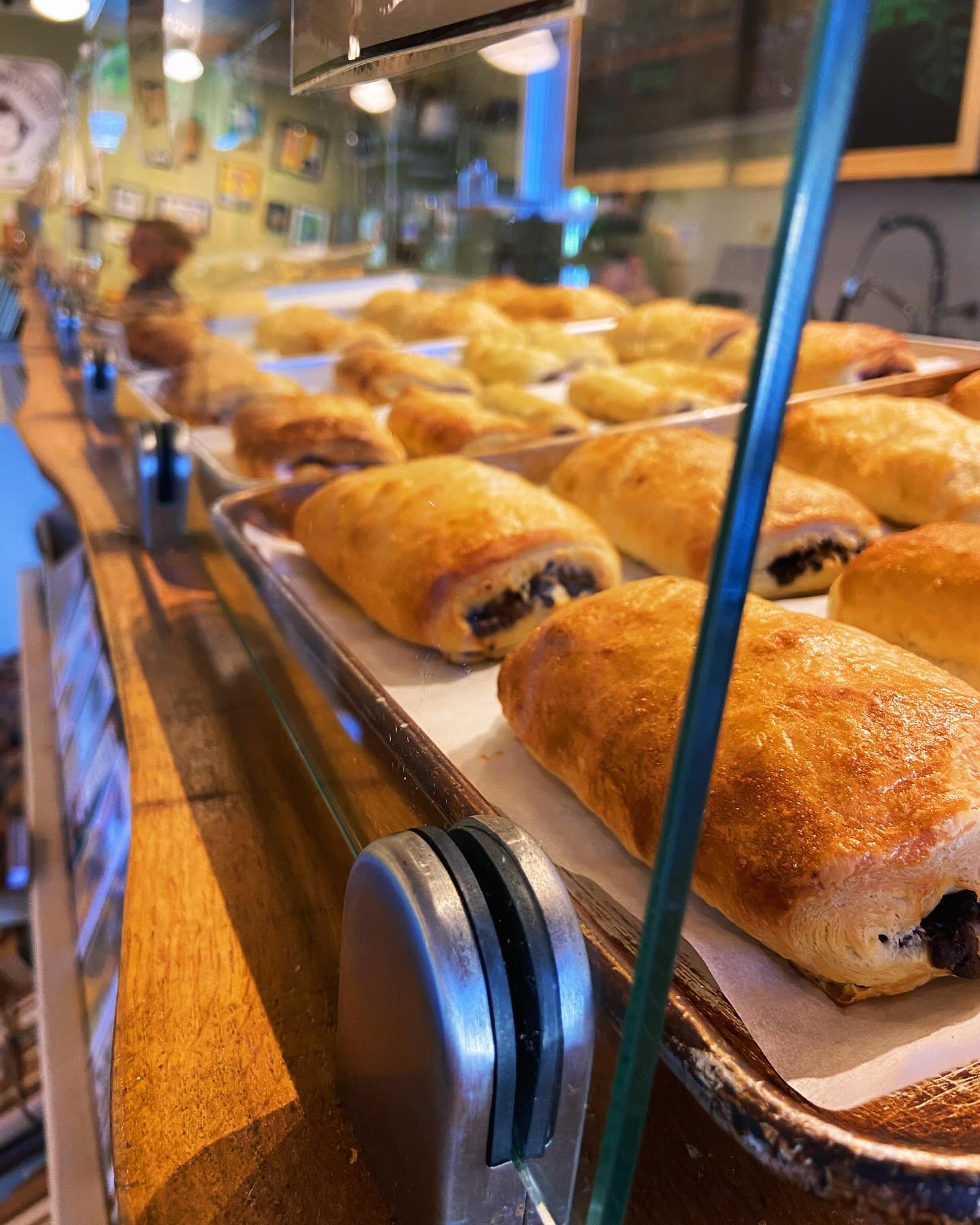 Pastries with chocolate filling on a tray inside a bakery display case.
