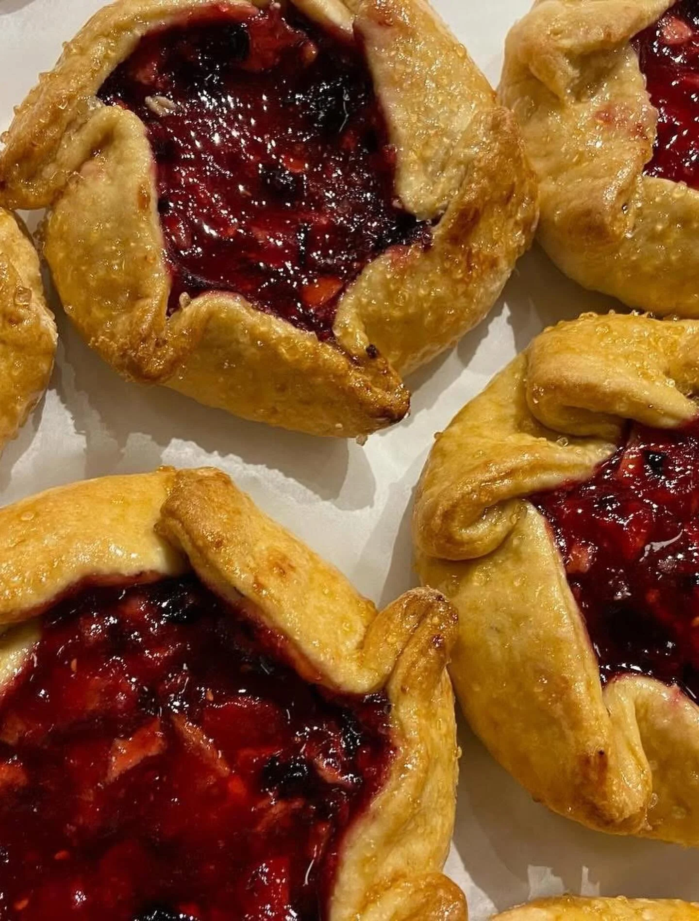 Close-up of freshly baked cherry danishes with golden crust and cherry filling.