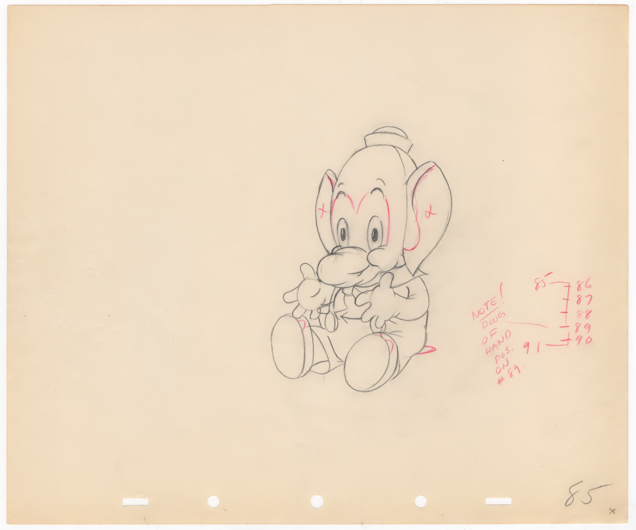 A colored pencil sketch of the cartoon character Dumbo, the flying elephant, on a piece of paper. There are handwritten notes and numbers in red ink next to the sketch.