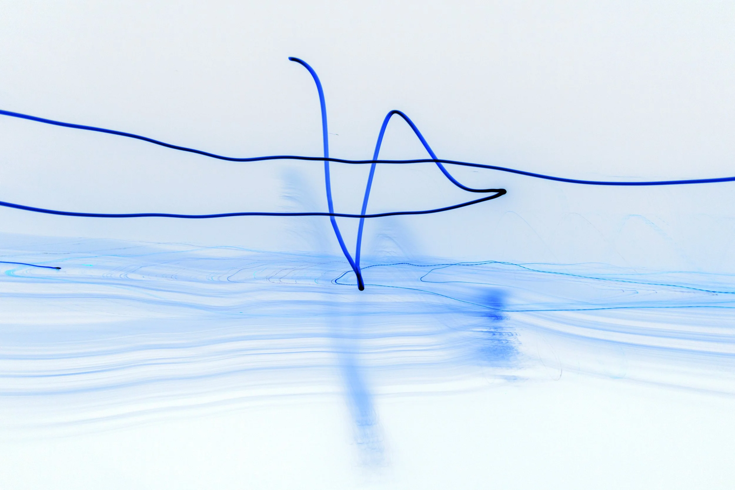 Abstract digital art with blue lines on a light background, creating wave-like and looping patterns.
