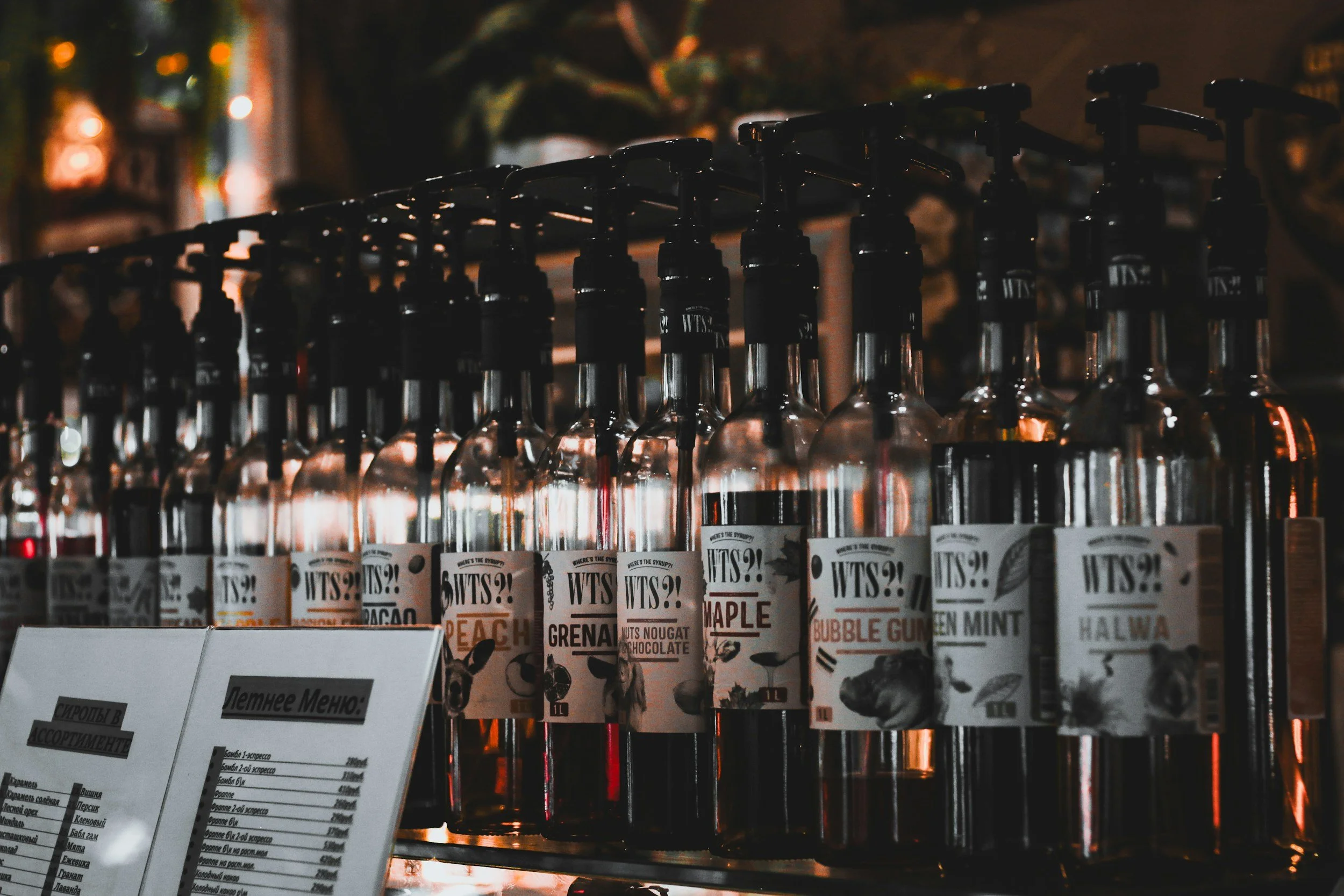 Line up of multiple glass bottles with black pumps.