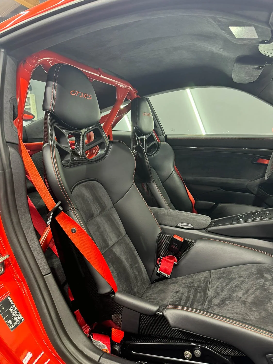 Innenansicht eines Porsche 911 GT3 RS mit Rennsitzen, Sicherheitsgurten und roll cage.
