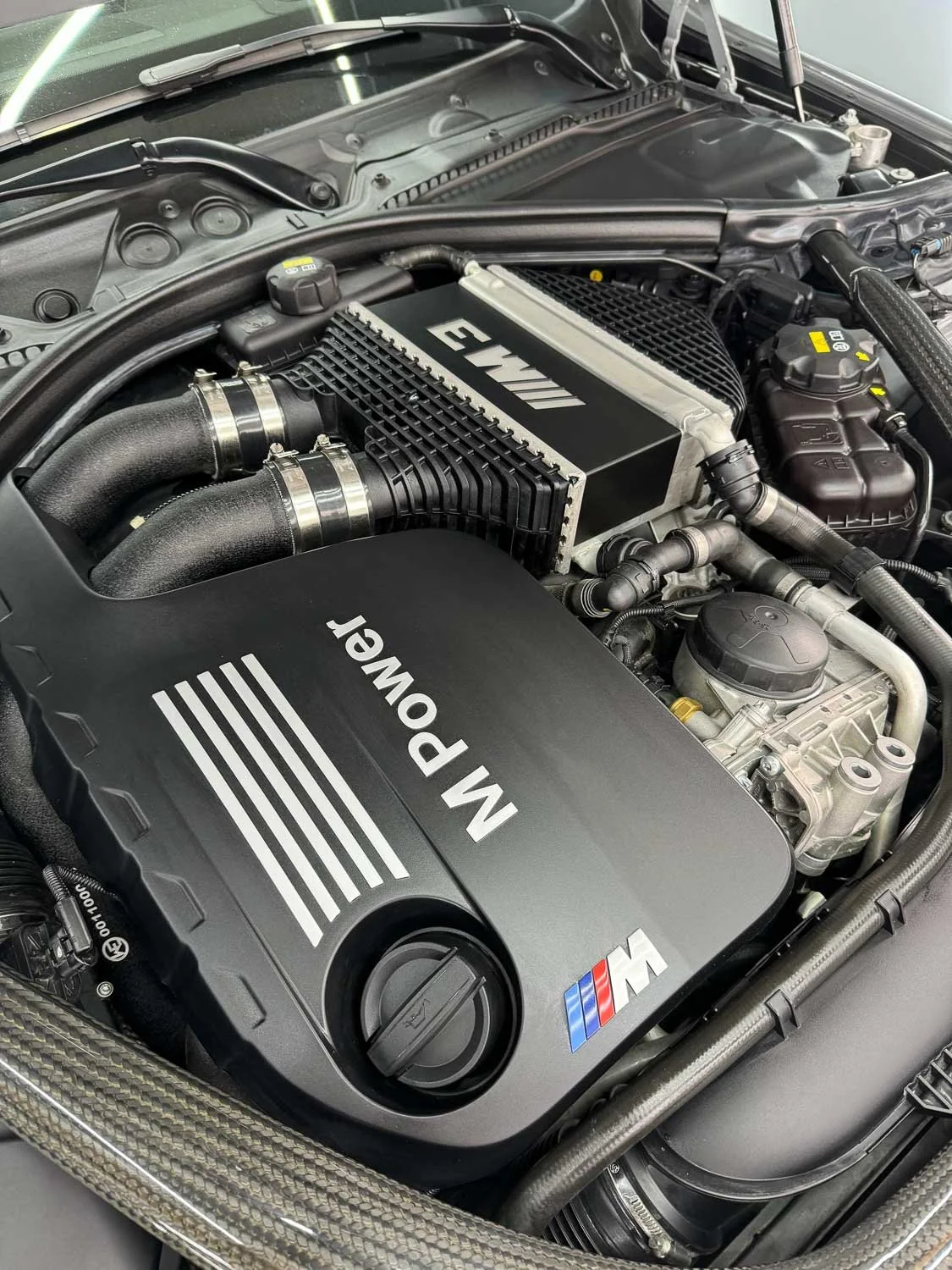 Motorraum eines Autos mit M Power und BMW M Logo