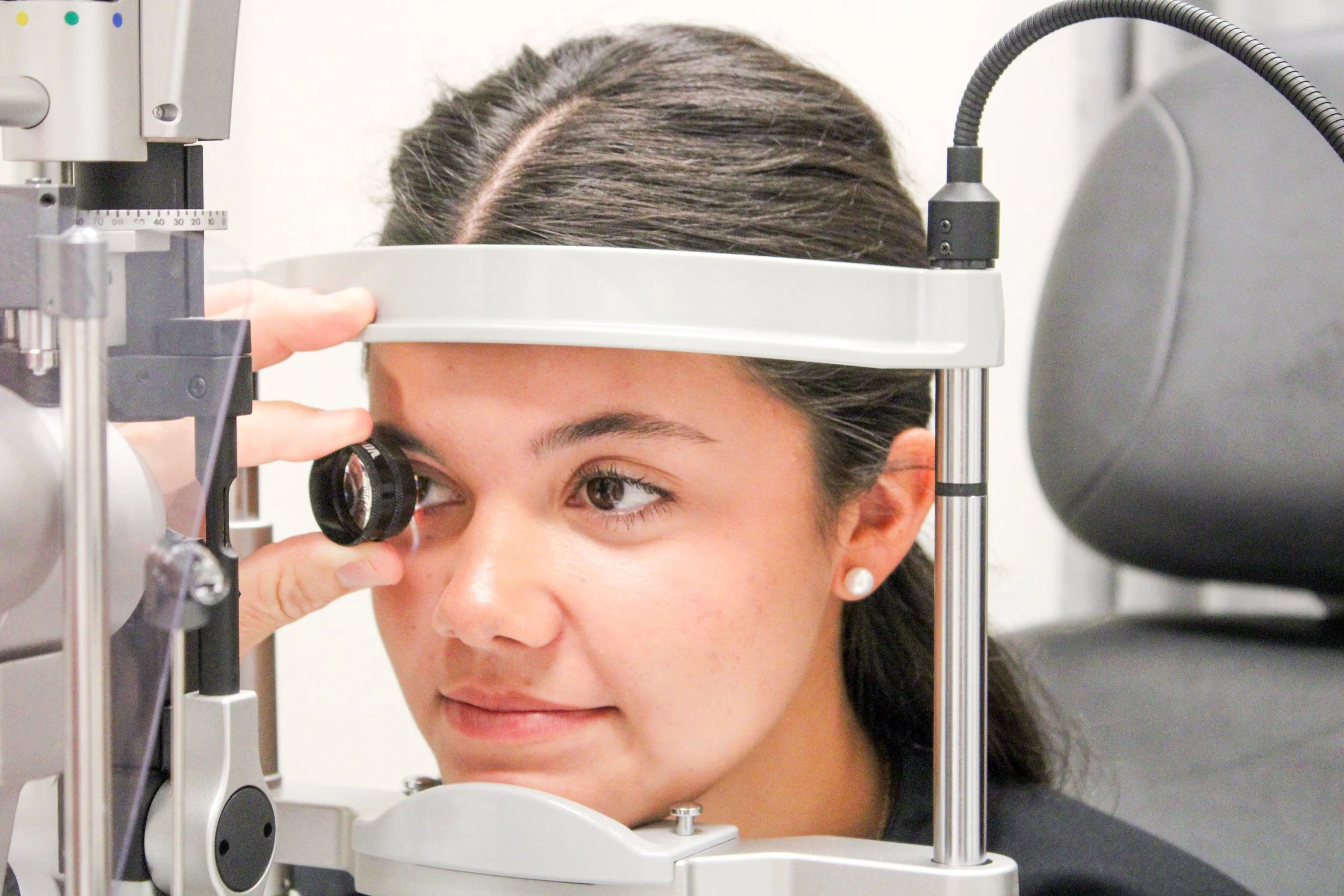 Young woman getting her eye examined with a slit lamp in an eye clinic.