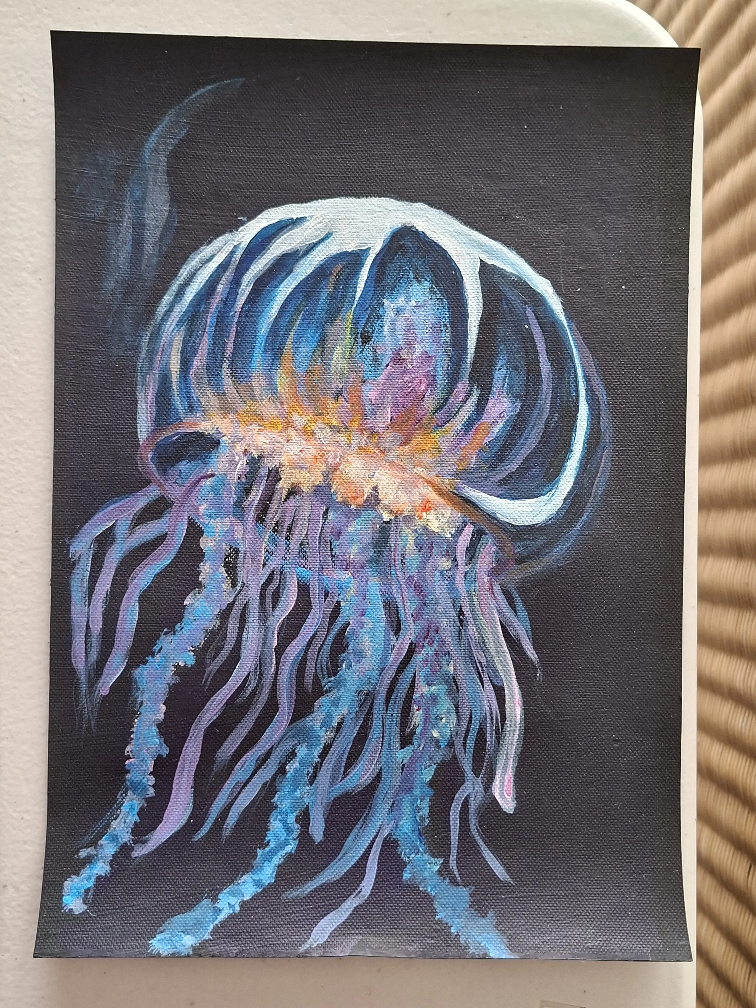 Painting of a jellyfish on a dark background, with glowing blue and purple tentacles and a translucent bell.