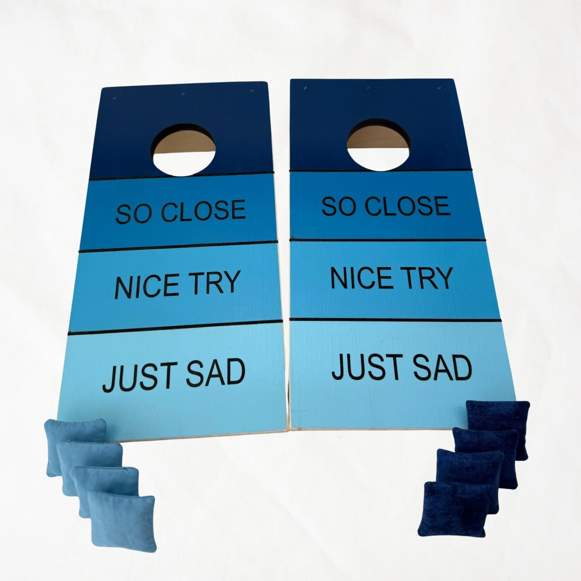 Handcrafted tabletop mini cornhole boards made from solid hardwood, So Close blue gradient design, shown with bags