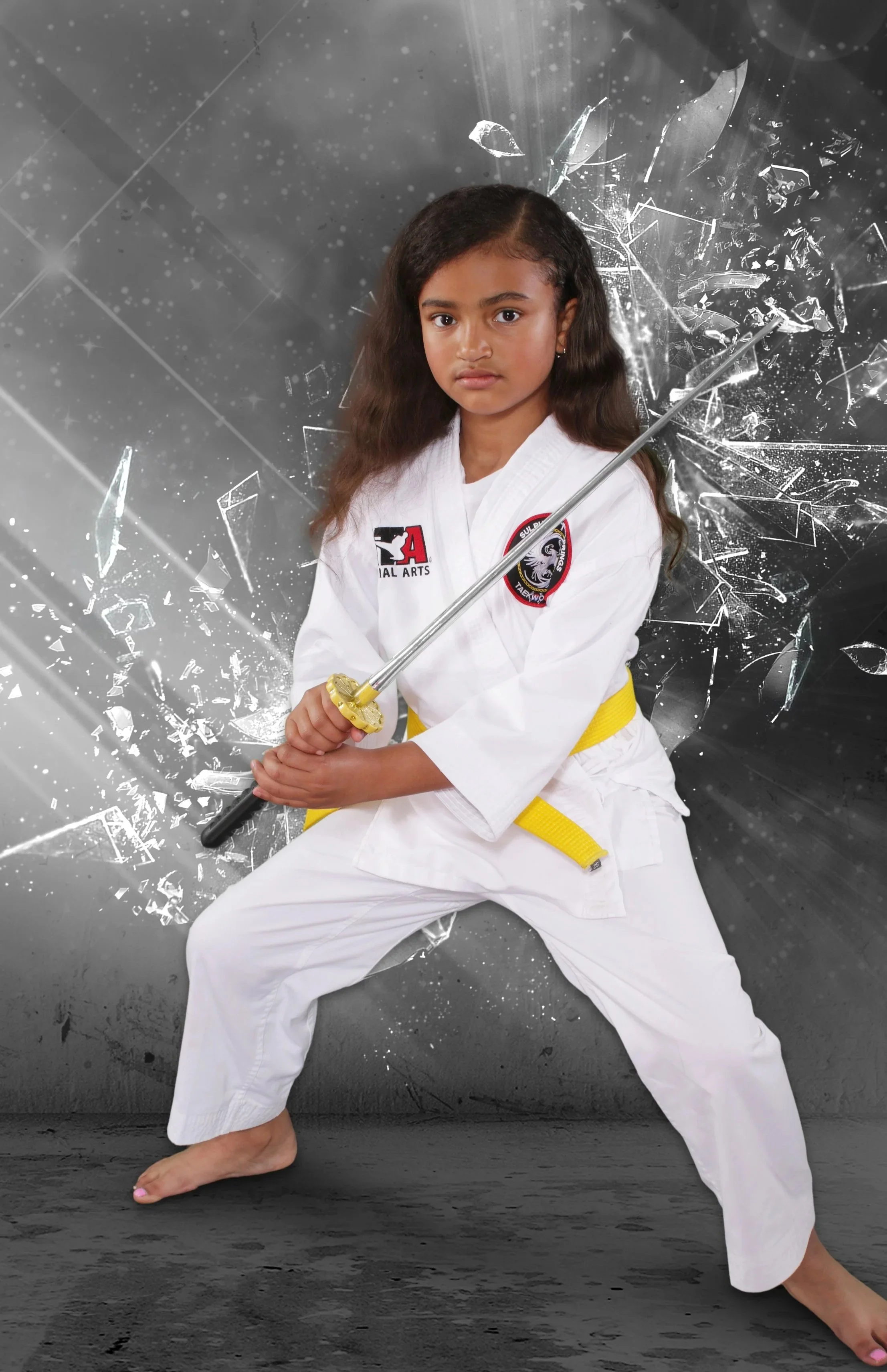 A young girl in a martial arts uniform holding a sword in a ready stance, with a shattered glass effect in the background.