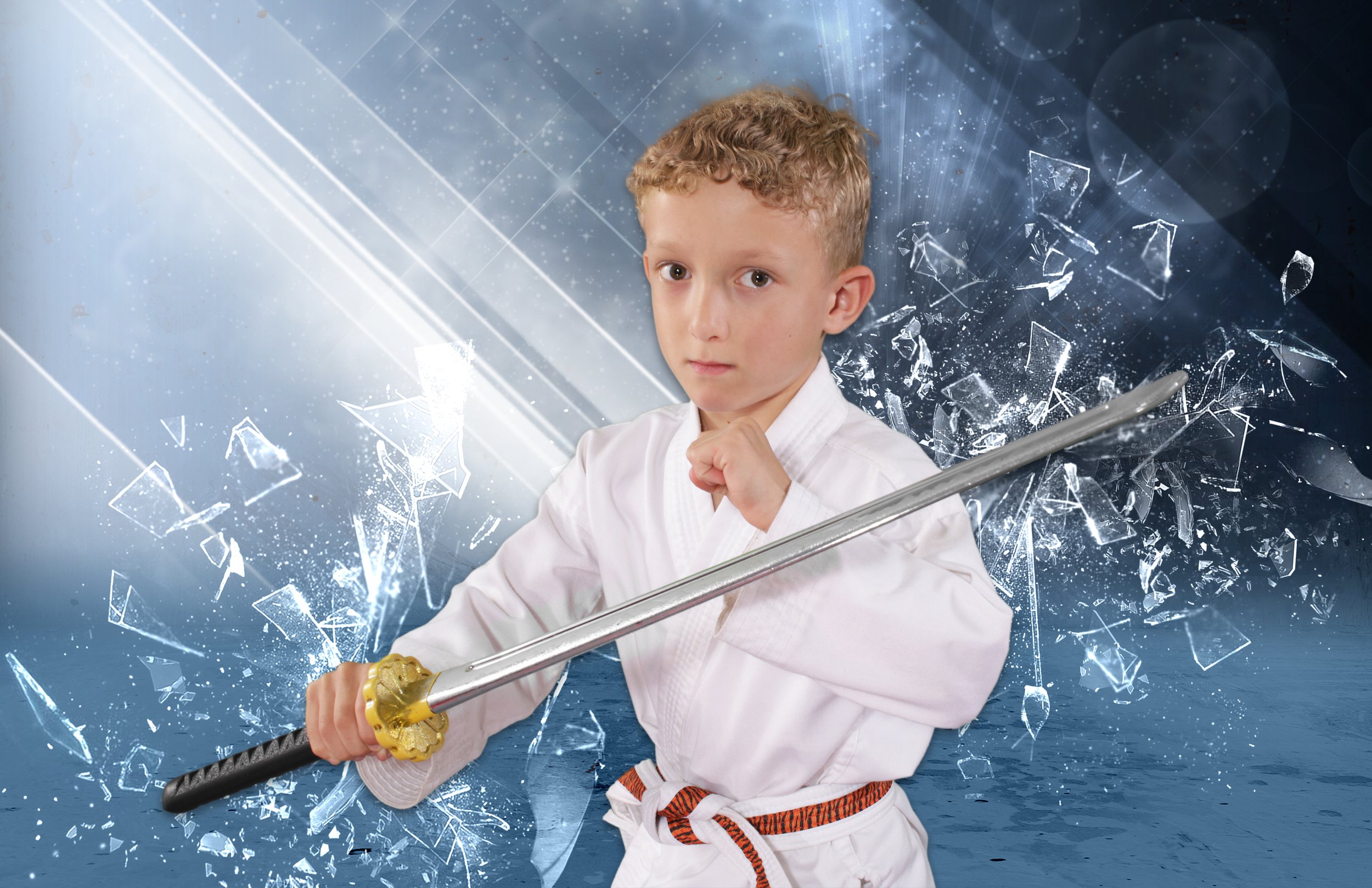 a young boy in an ATA Martial Arts uniform holding a plastic sword
