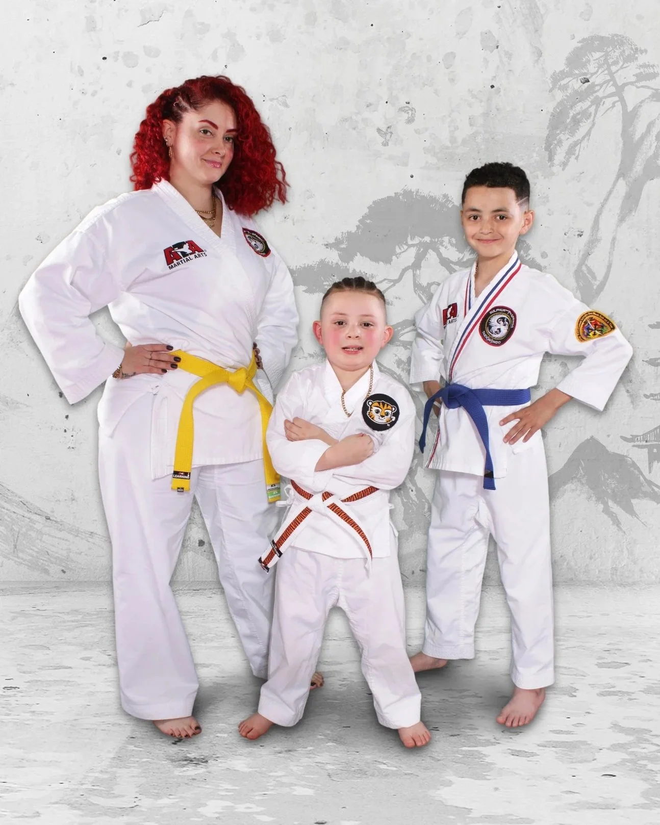 an image of a mom and her two sons in ATA Martial Arts uniforms.