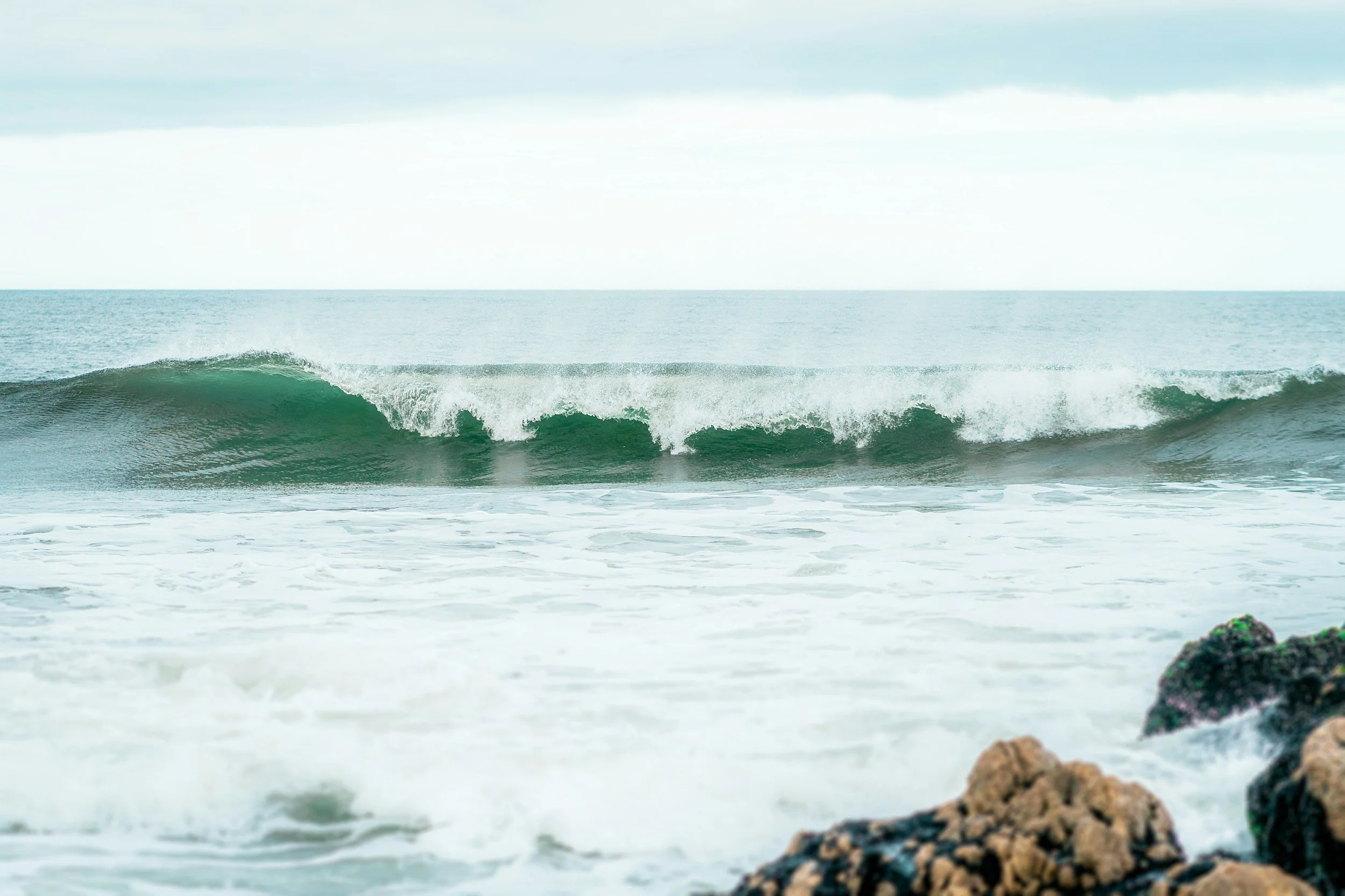 Wave crashing near rocking coast 