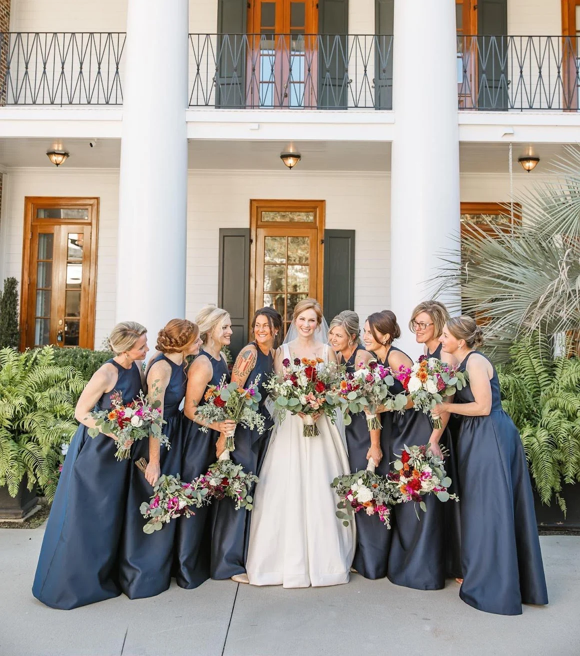 A Greenville, SC bride poses in front of Magnolia Hall with her bridesmaids. 