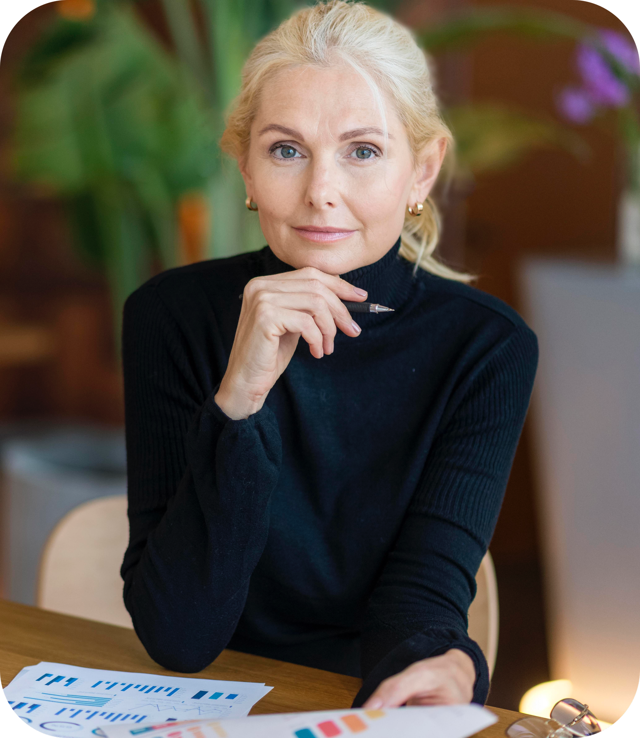 Eine Online-Psychologin schaut in die Kamera und trägt einen schwarzen Rollkragenpullover.