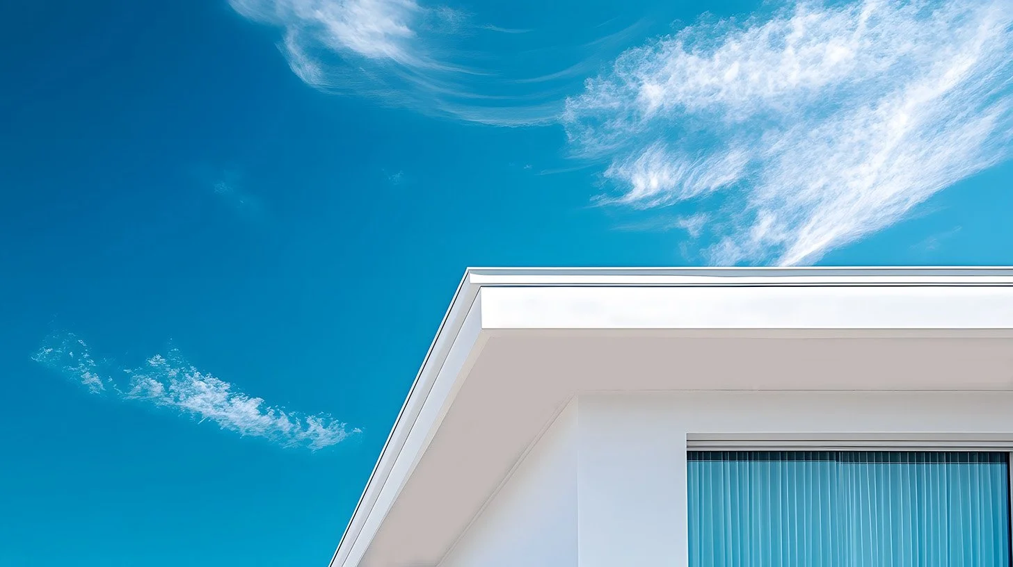 Stylistic image of the upper corner of a modern white house and window and a blue sky.