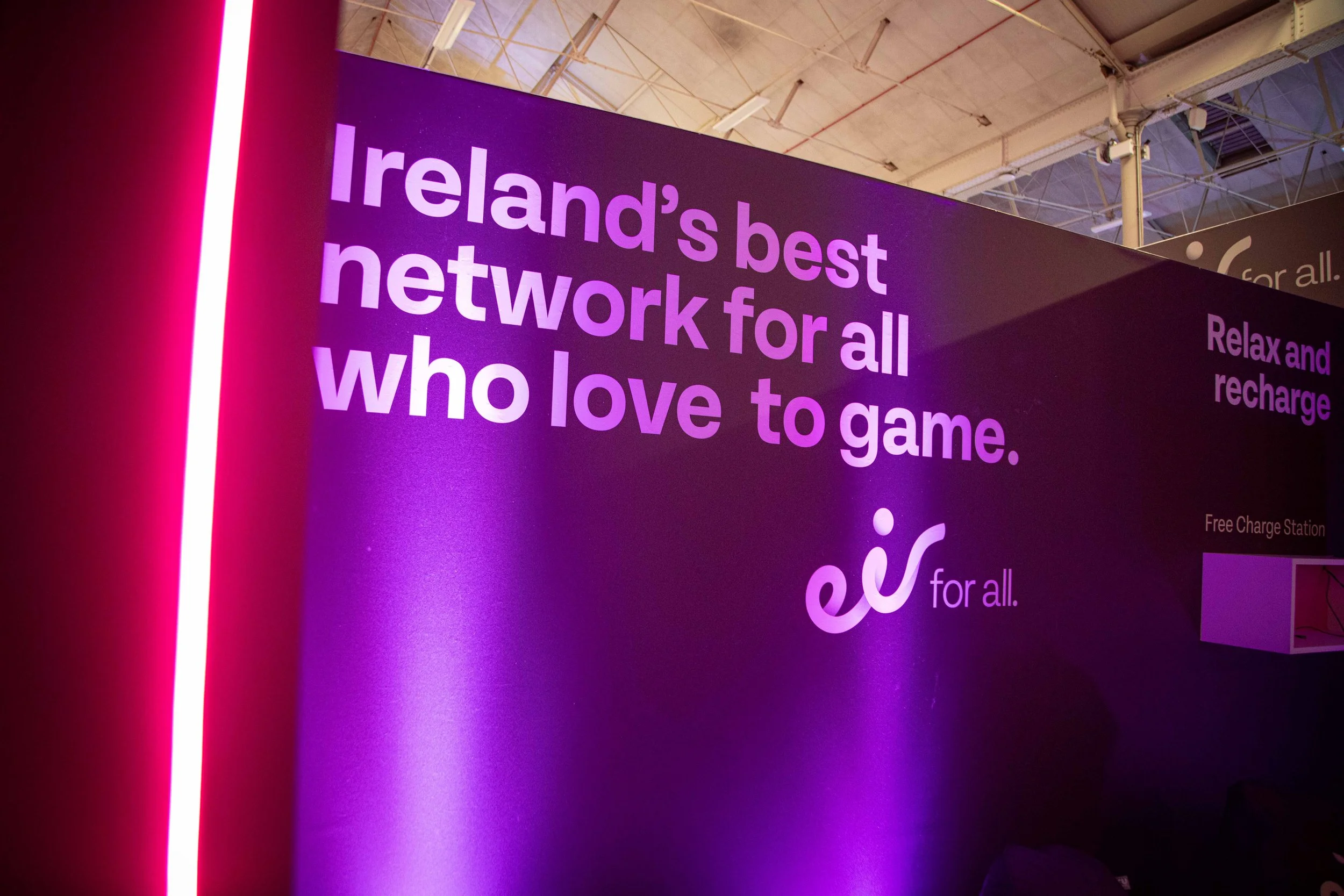 A purple and black display with the text 'Ireland's best network for all who love to game' and a neon pink vertical light on the left side.