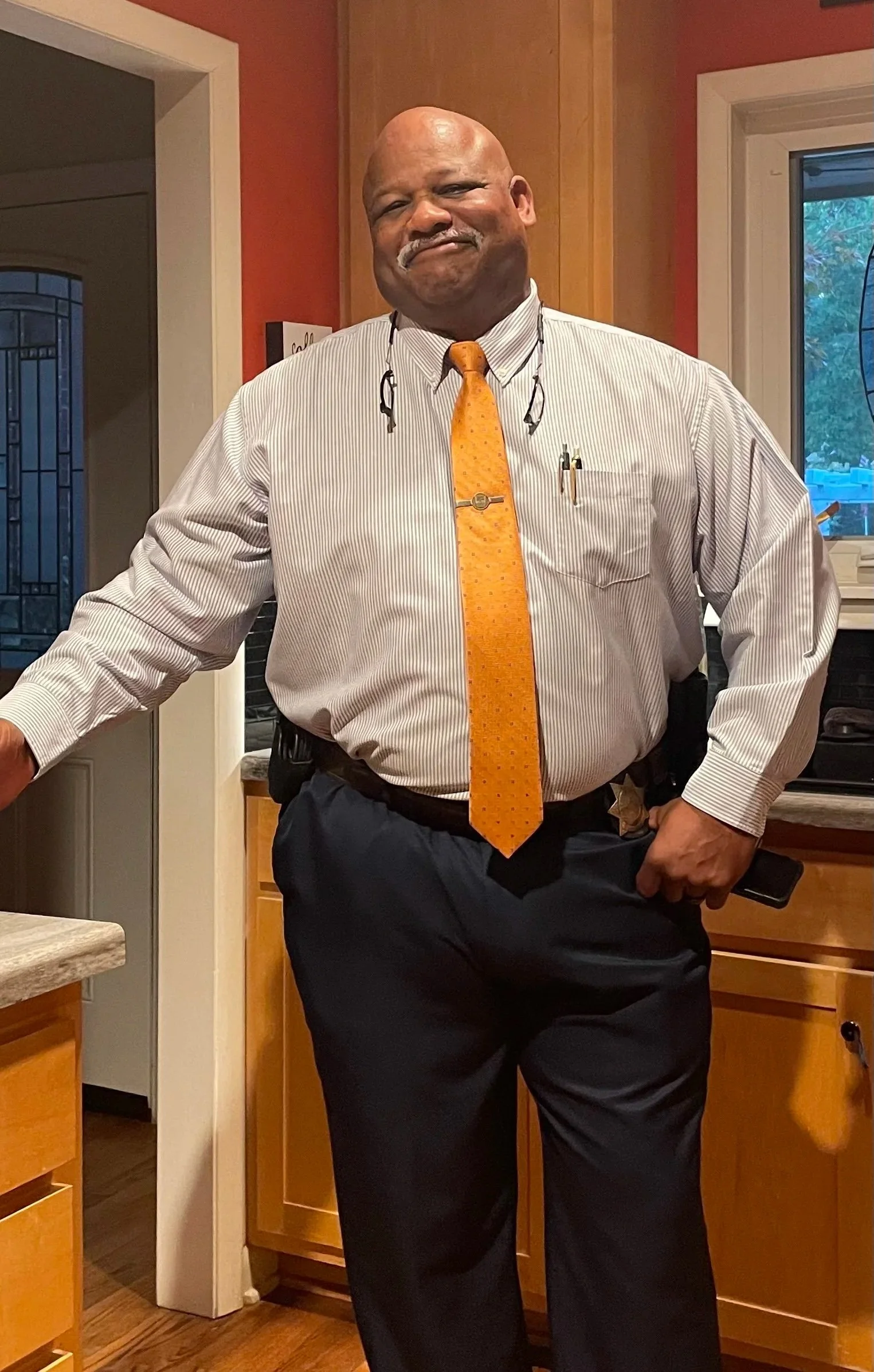 Man standing in kitchen, smiling