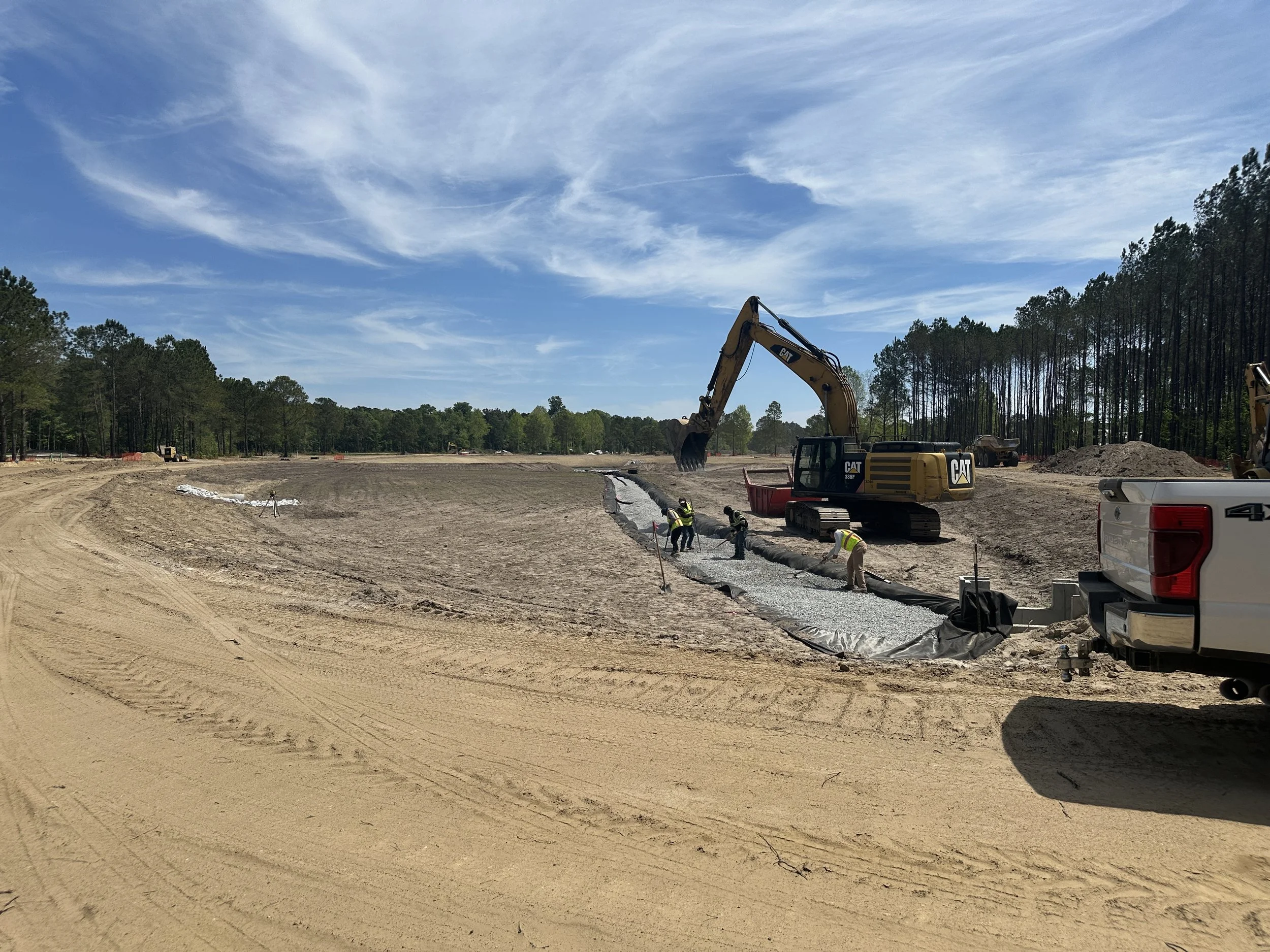 Fench drain being installed in dry pond that will serve as a park in Pondcrest Phase of Habersham