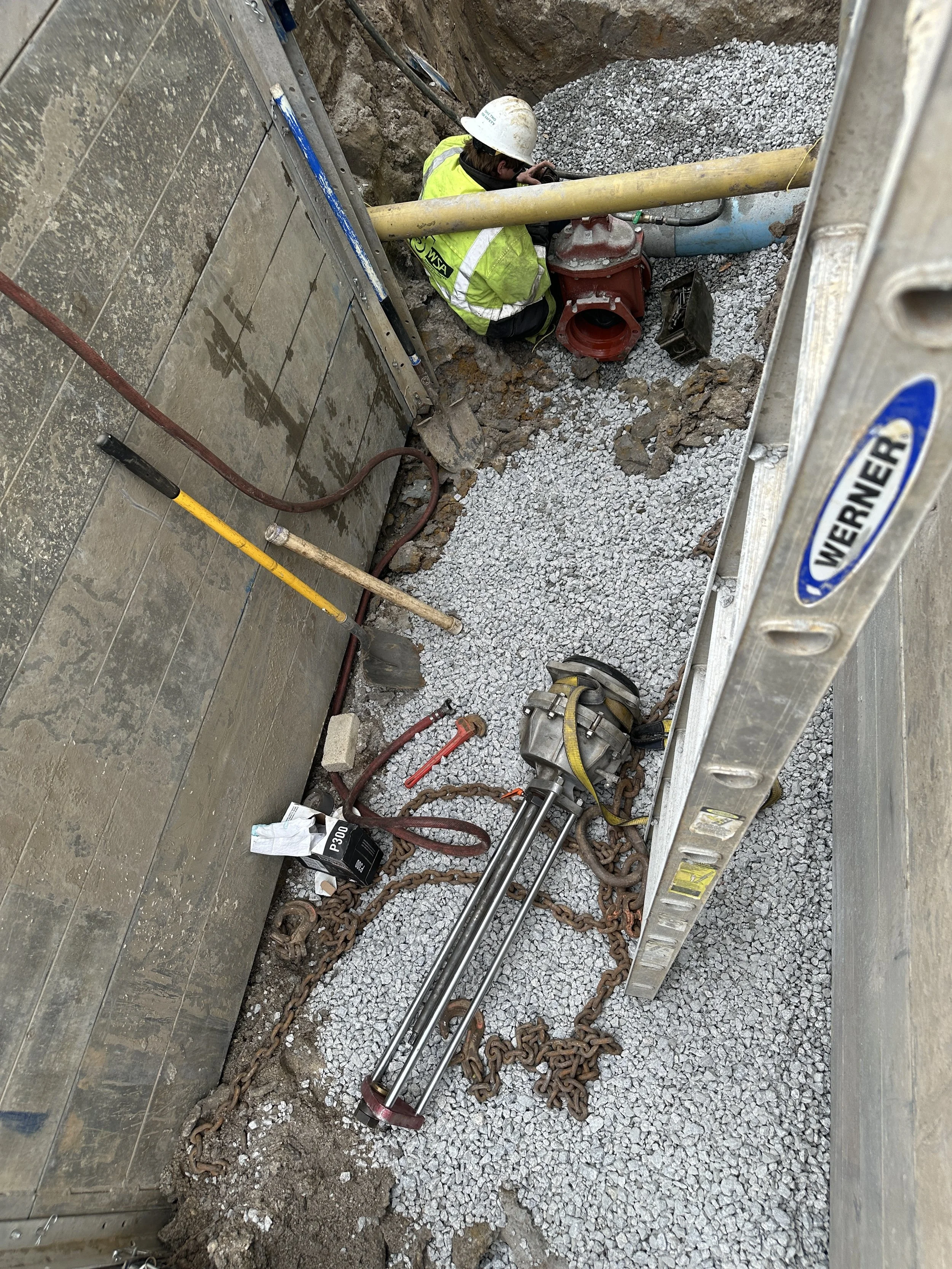 Tapping saw lowered in hole to tap water main