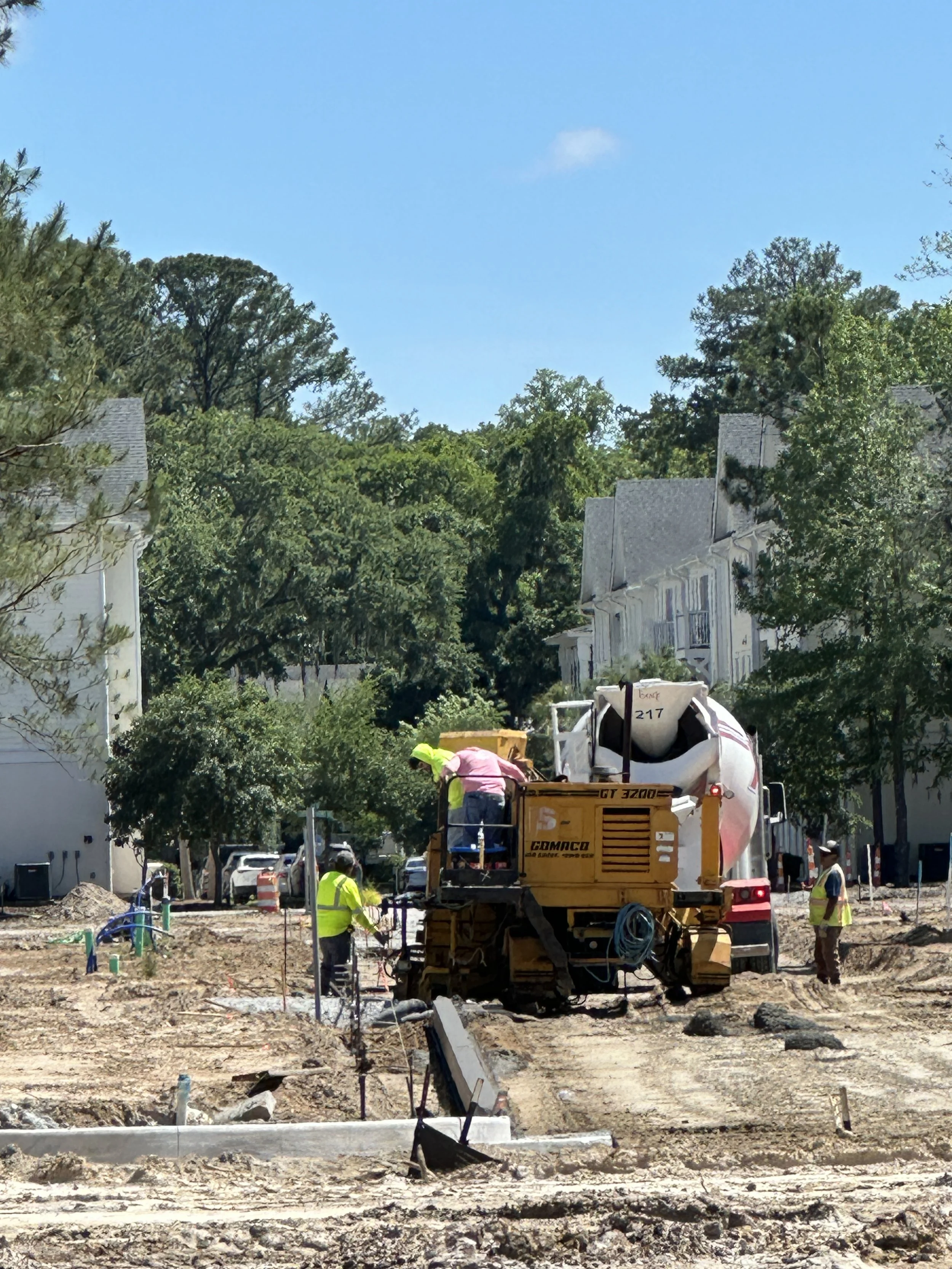 A crew using a curb machine to lay curb in new phase of Habersham, called Pondcrest
