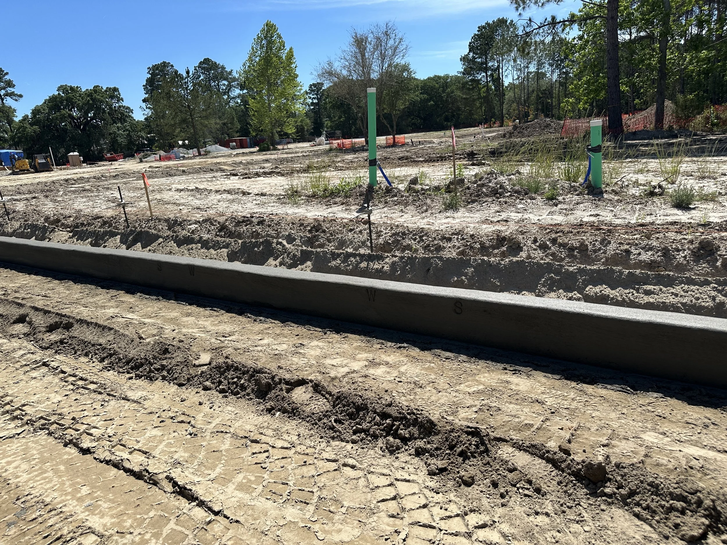 Freshly machined curb with water and sewer stamps in it located in the new phase of Habersham, called Pondcrest