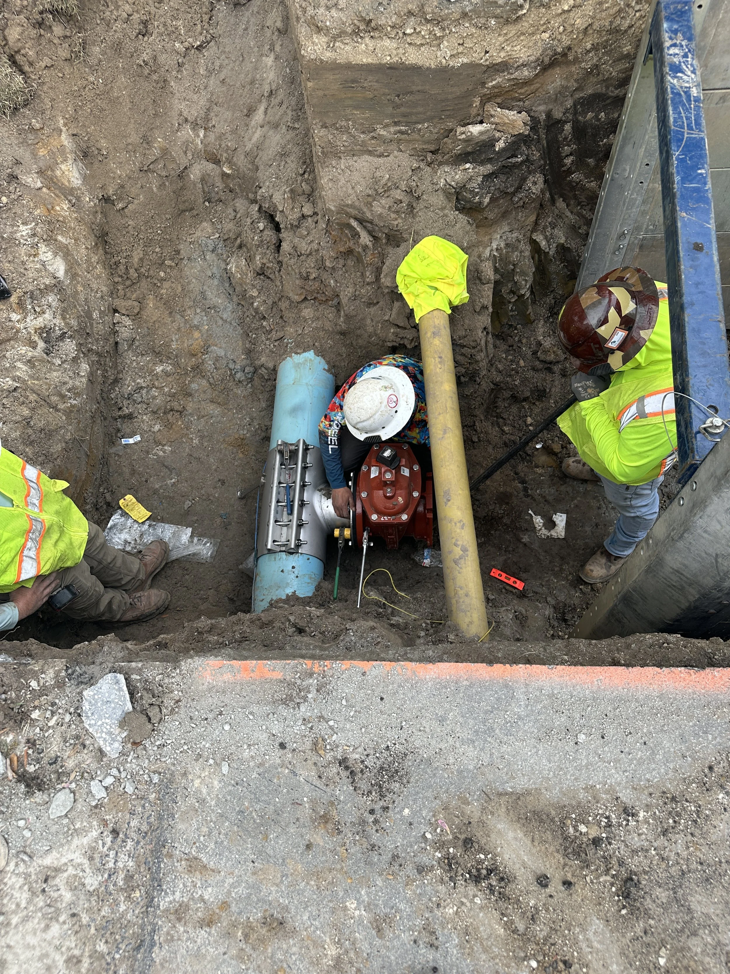 Attaching gate valve to tapping saddle for water connection while bypassing gas line