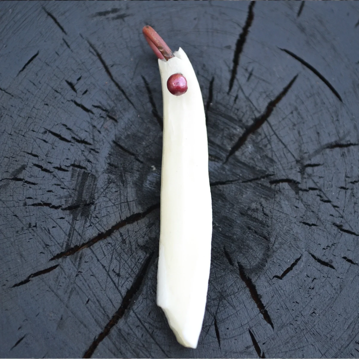 Bespoke pet tooth heirloom keepsake set in metal, displayed on a black wooden surface.