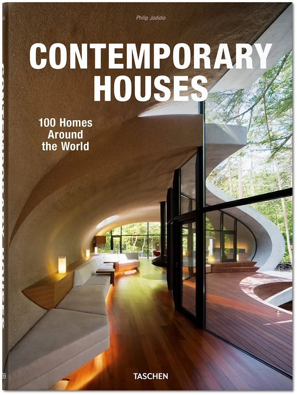 Couverture de livre intitulée "Contemporary Houses: 100 Homes Around the World" présentant un intérieur contemporain avec un plafond incurvé, des fenêtres en verre et une vue sur la nature extérieure.