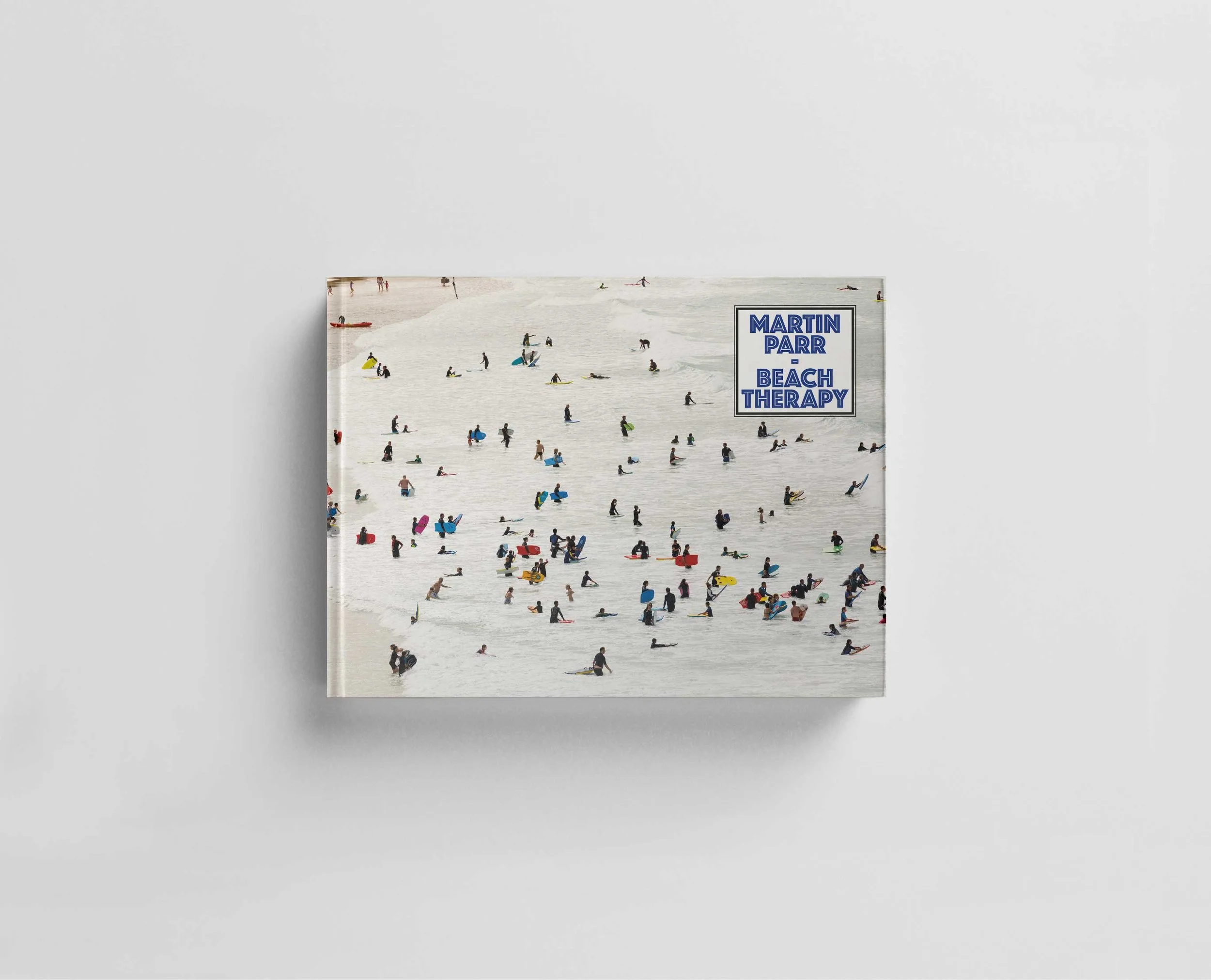 Livre intitulé 'Martin Parr Beach Therapy' avec une couverture montrant une plage animée avec de nombreuses personnes dans l'eau et sur la plage.