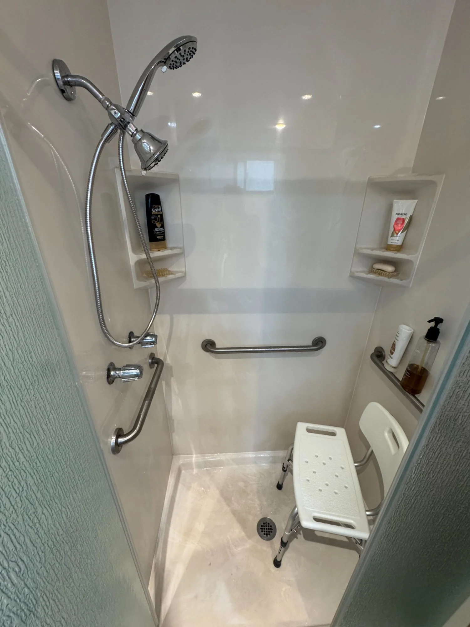 Walk-in shower with grab bars, bench, and handheld showerhead, home accessibility installation