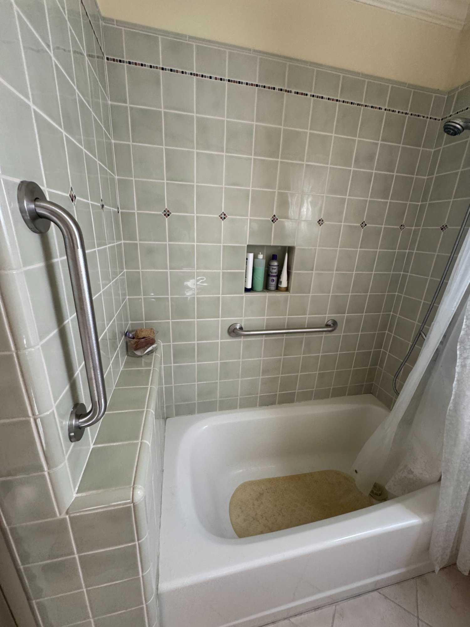 Grab bars installed in bathtub with sage green tile, home accessibility upgrade Northern California