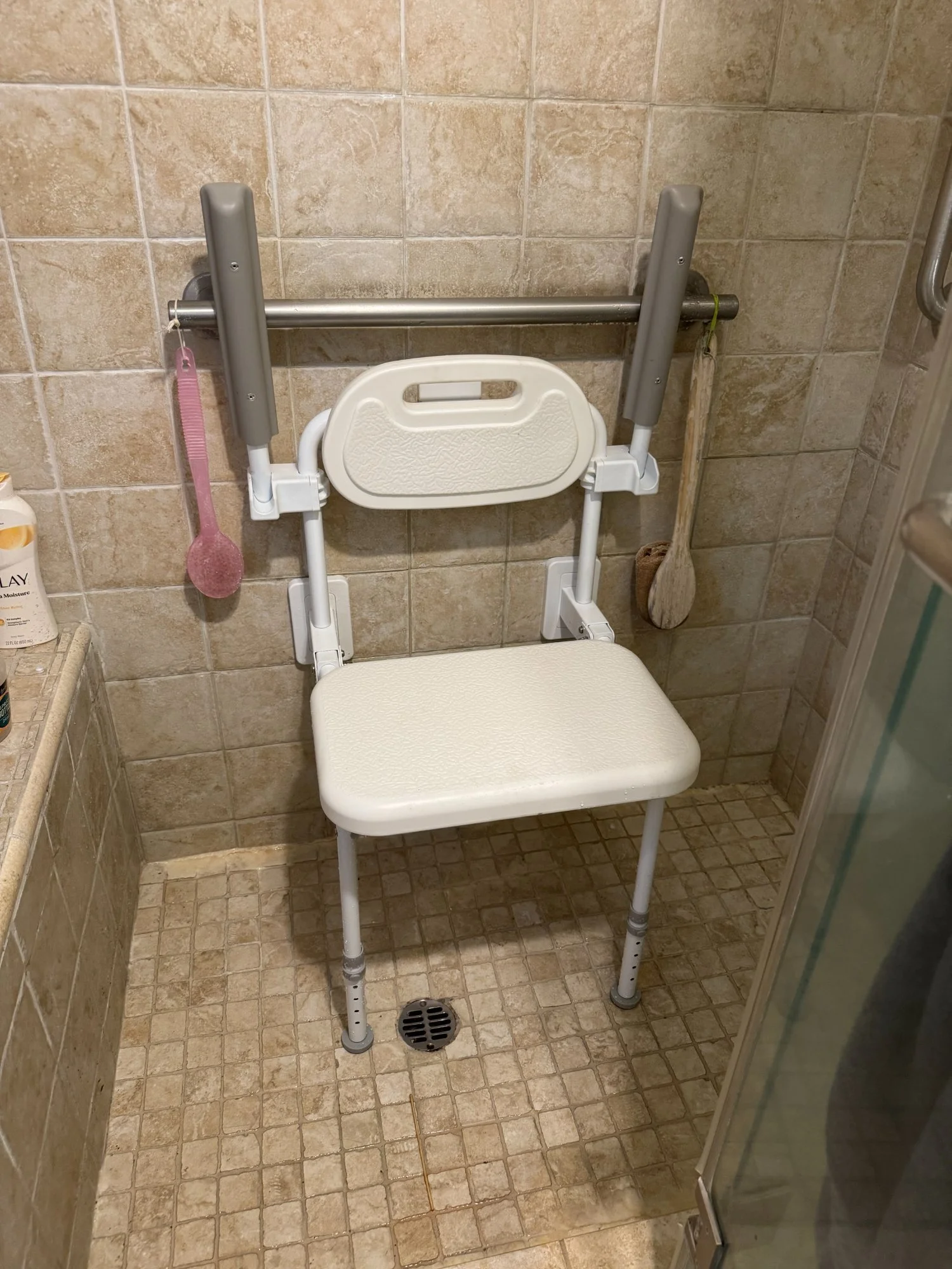Mounted folding shower chair and grab bar installed in walk-in shower, durable medical equipment setup