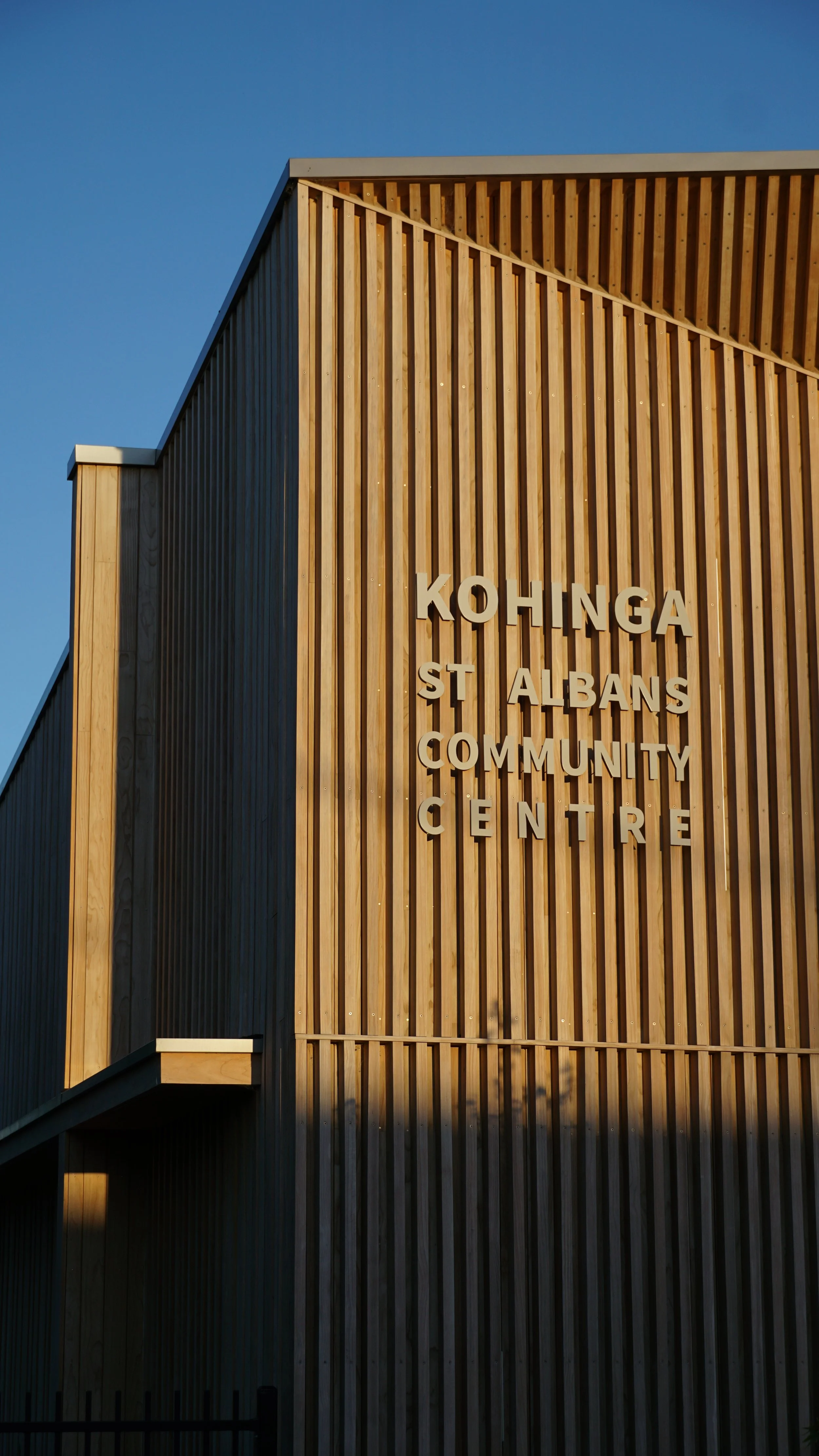A modern building with vertical wooden slats and a sign that reads 'Kohinga St Albans Community Centre' on the front.