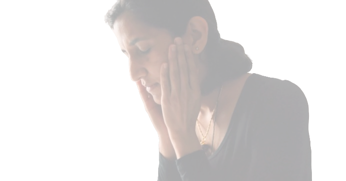 A woman with dark hair holding her head with both hands