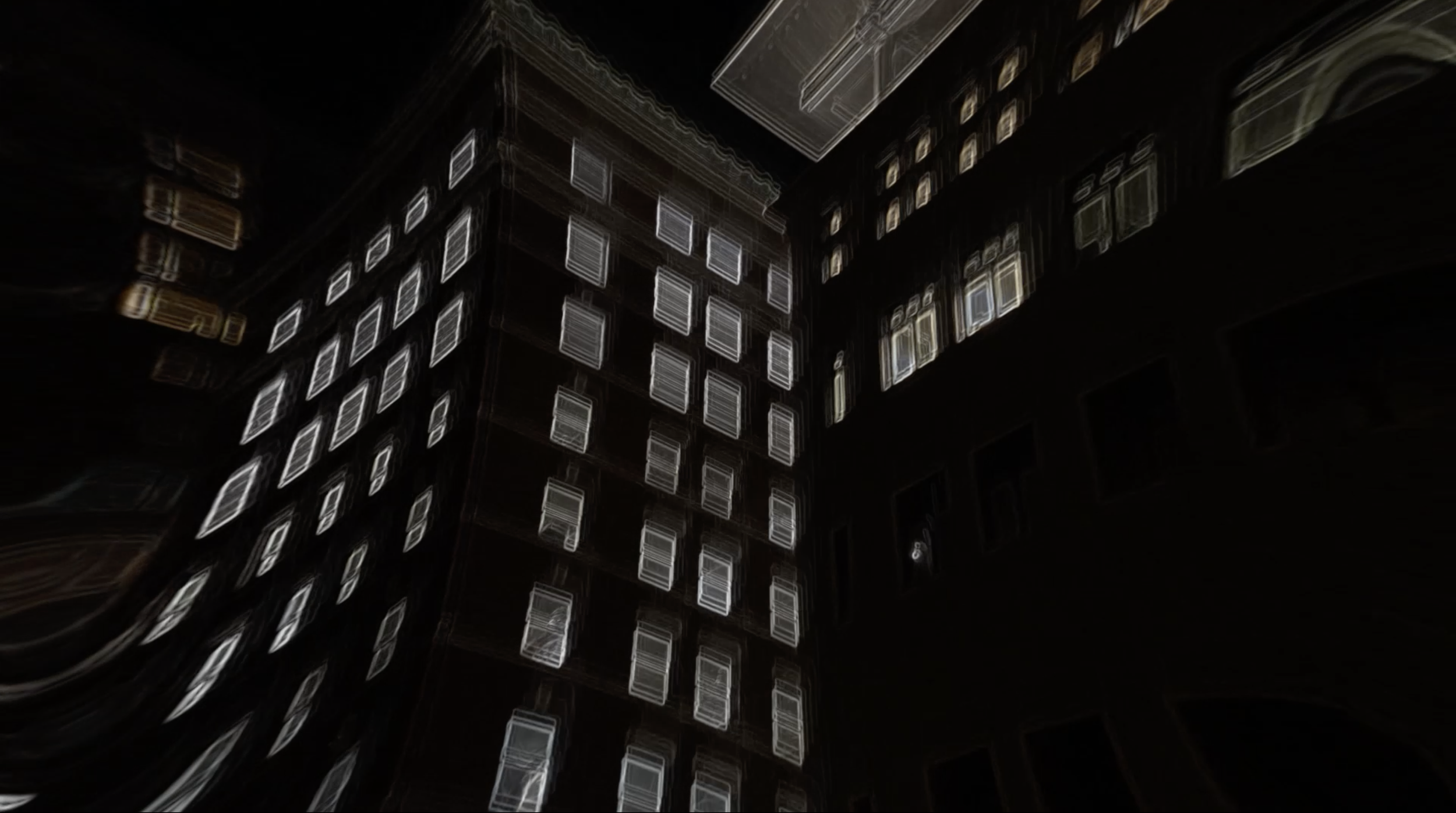 Nighttime photo of a tall building with illuminated windows, taken from below with a wide-angle lens creating a distorted, swirling effect.