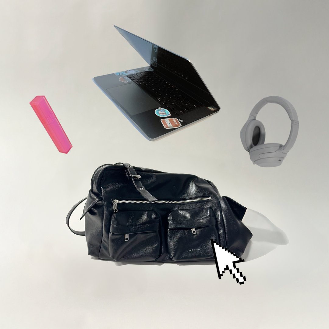 A black leather backpack with multiple zippers on a white surface, surrounded by a pink lipstick case, a silver laptop with stickers, a headset, and a pixelated cursor pointer icon.