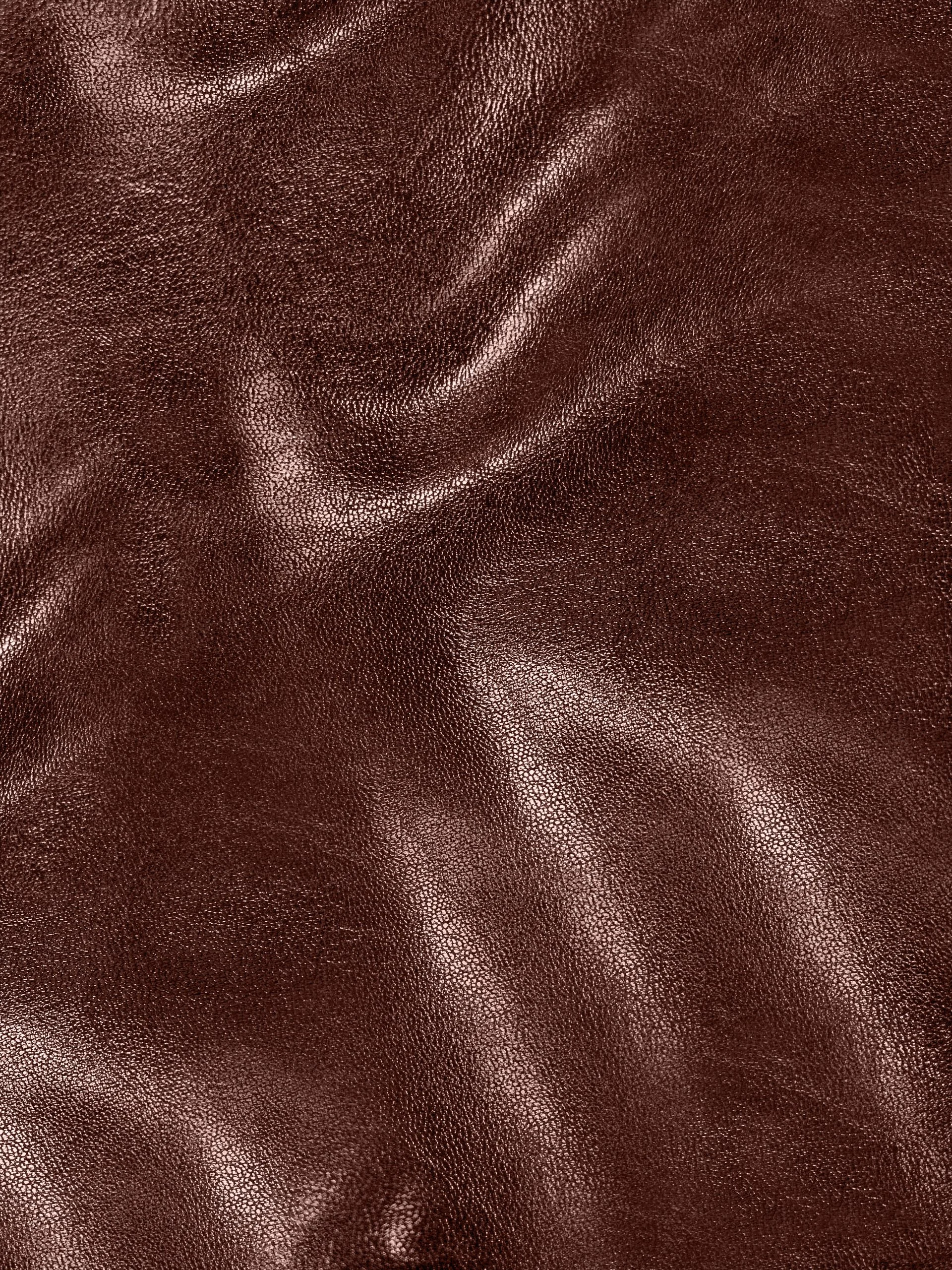 Close-up of brown leather surface with visible grain and texture.