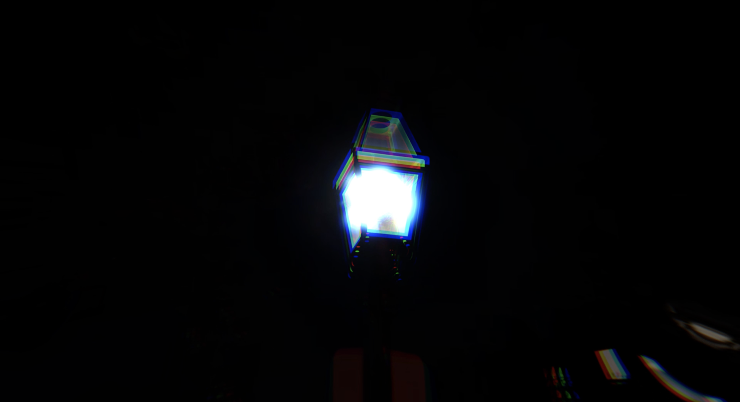 A brightly lit street lamp at night with digital distortion effects.