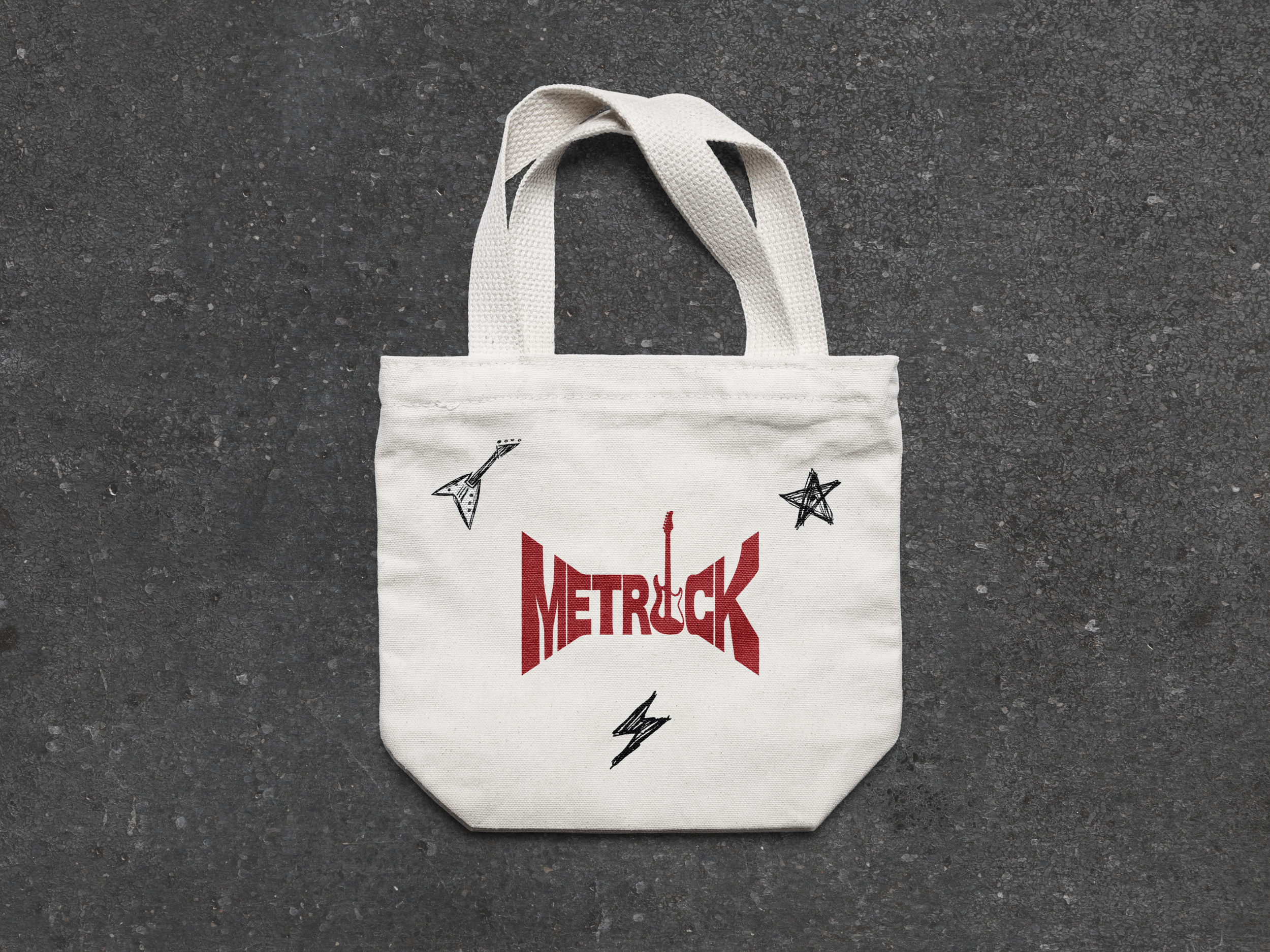 A white canvas tote bag with black and red graphic design on a gray textured surface.