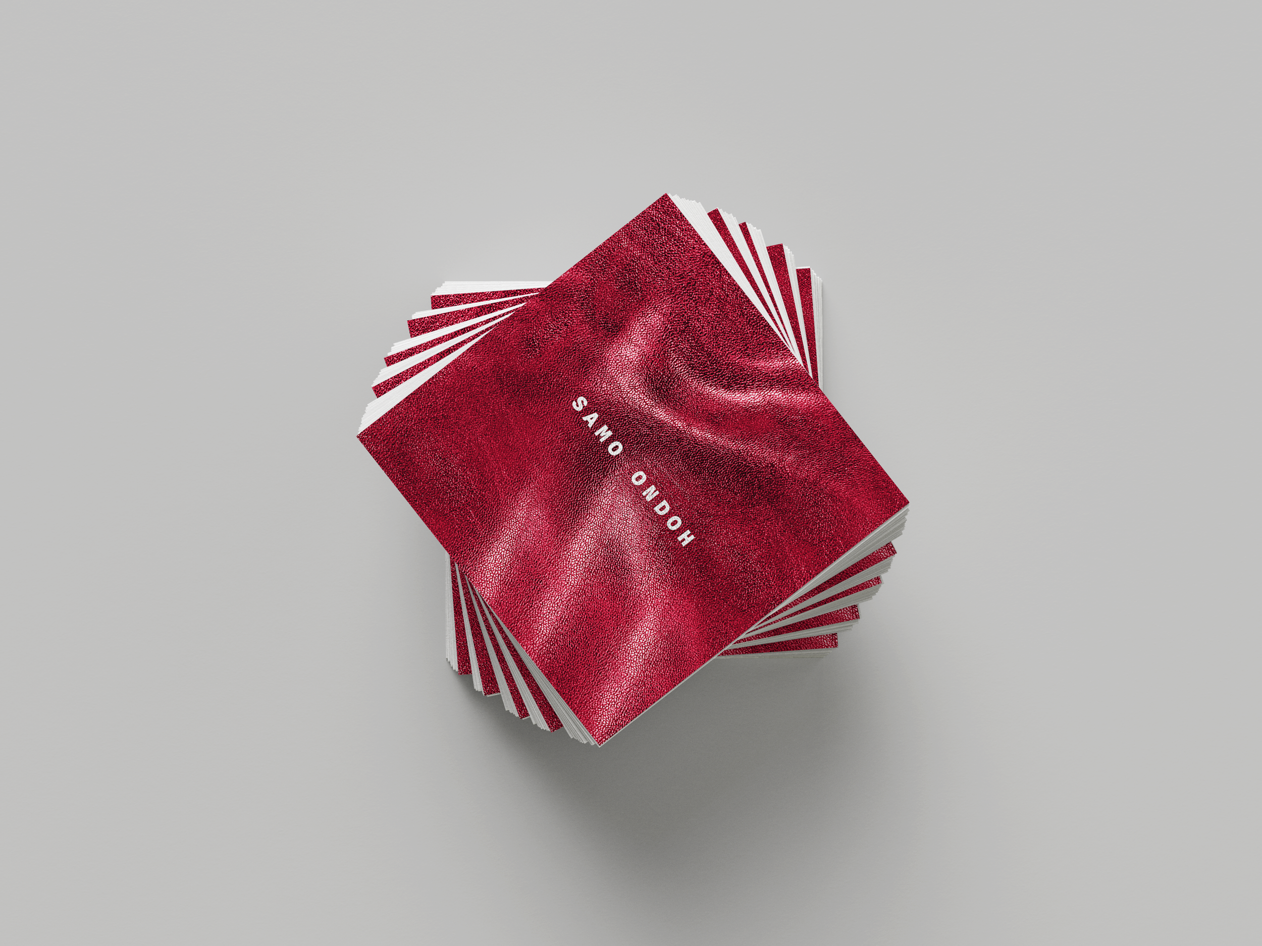 A stack of red playing cards with the words 'HONGO ONDO' written on the top card, fanned out in a circular pattern on a gray background.