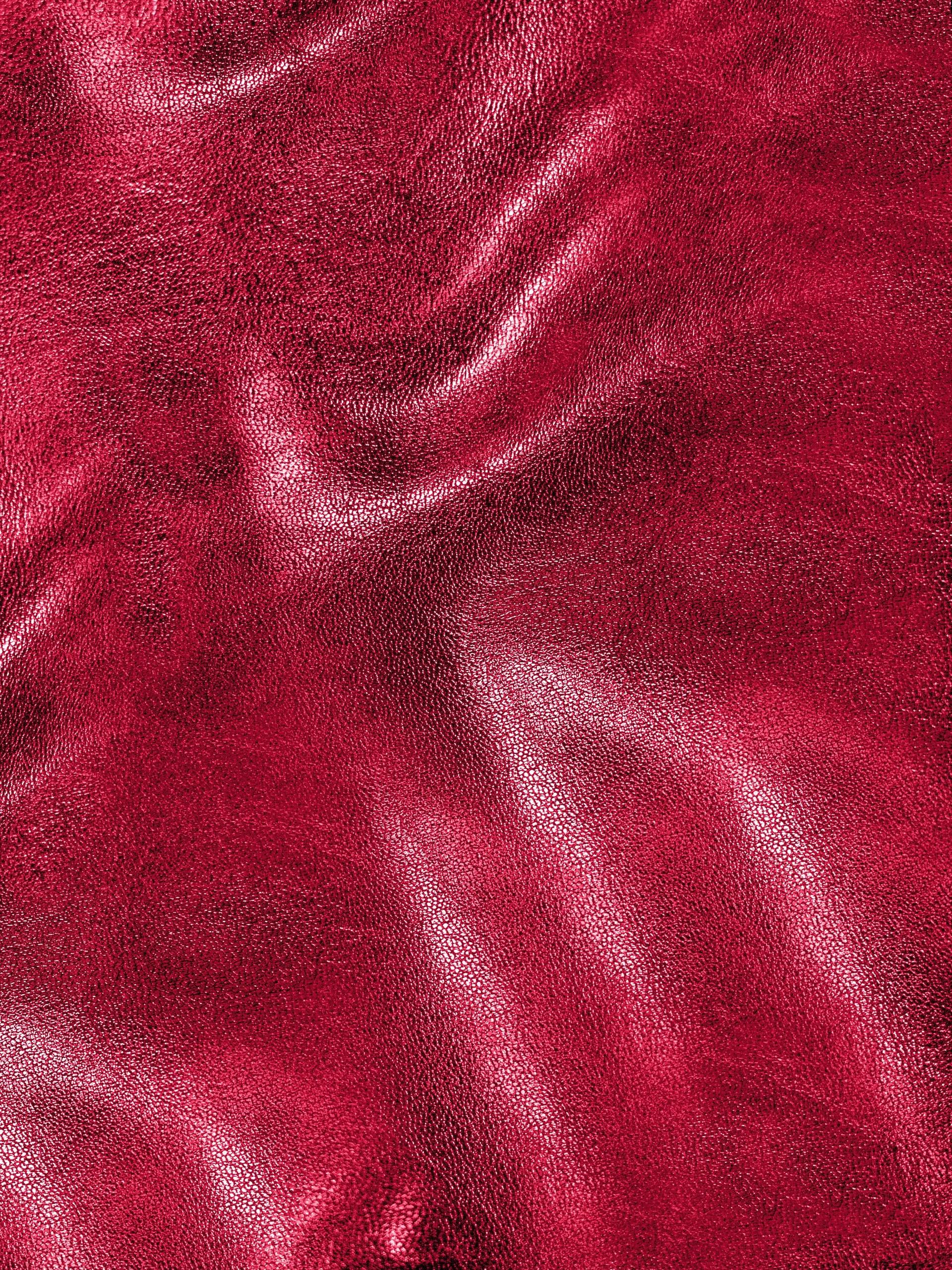 Close-up of red textured leather with visible grain and folds.