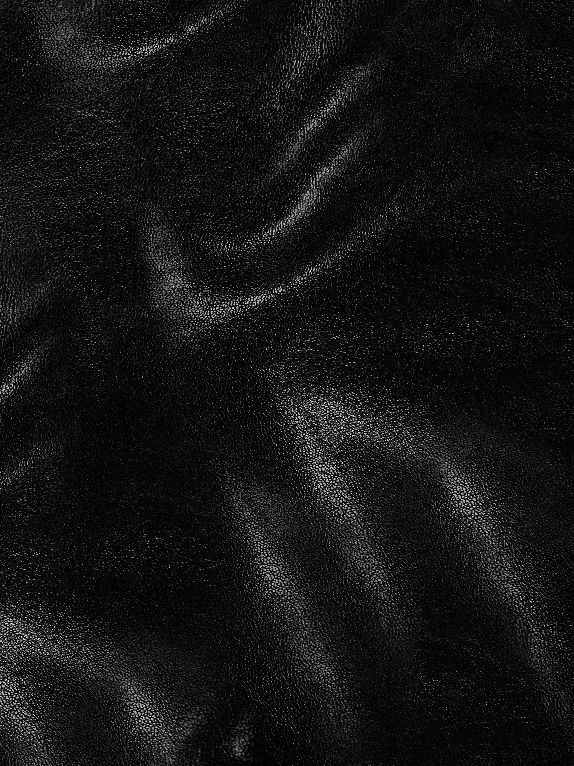 Close-up of black leather fabric showing texture and sheen