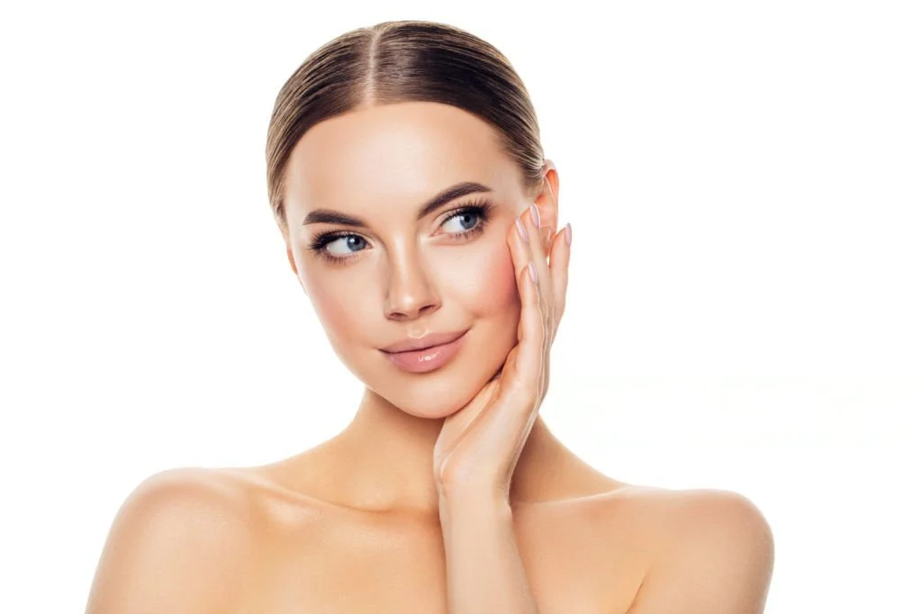 Woman touching her face representing aesthetic dermatology services at Isla Dermatology in Key West