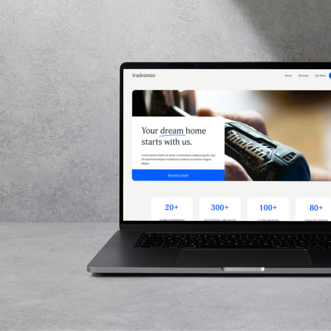 A laptop with a website displaying a home improvement or construction company's webpage, featuring a hand holding a tool and text about building a dream home.