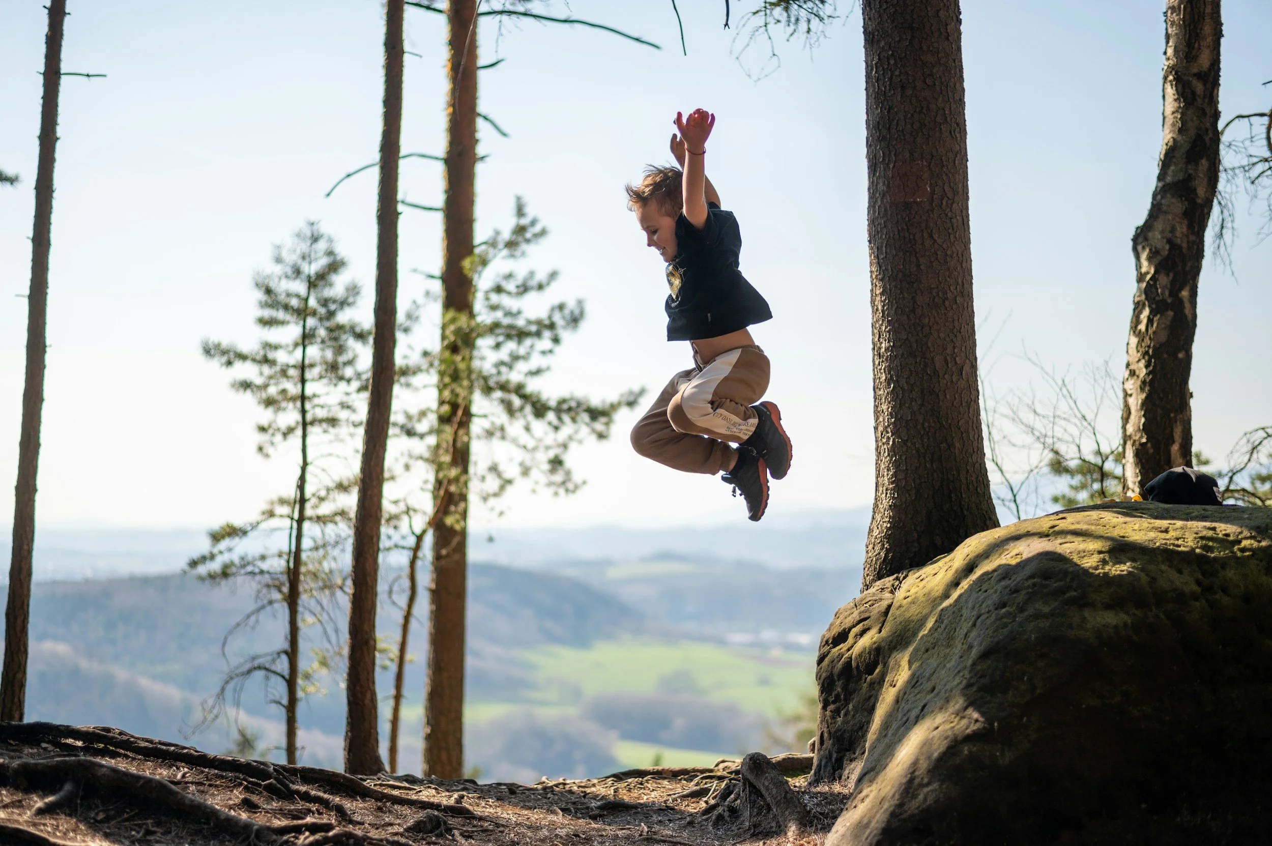 boy jumping off rock