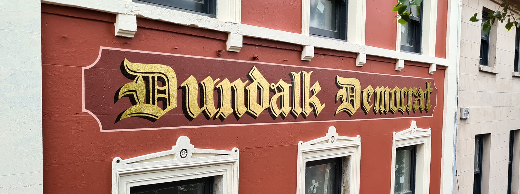 Street view of a building with a mural that reads 'Humboldt Veterans' in gold and black Gothic lettering on a reddish-brown background.