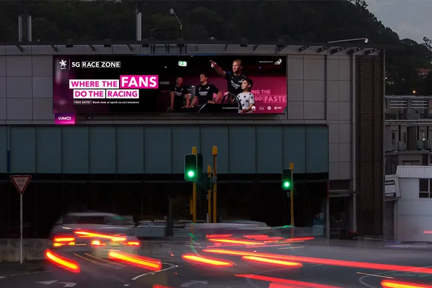 Large format Spark 5G Race Zone billboard installation above city traffic